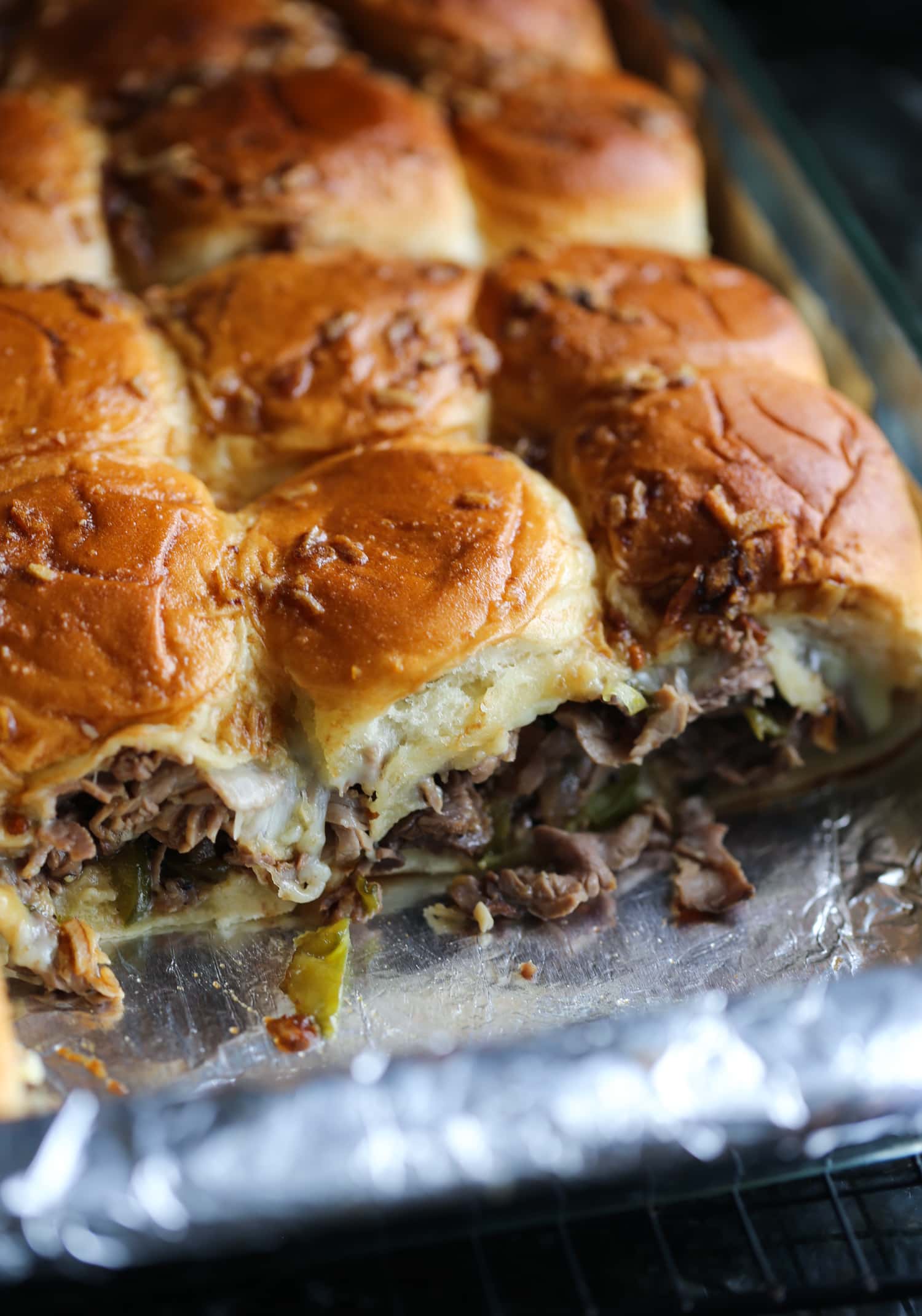 Deslizadores de bistec con queso Philly en una fuente para horno a la que le falta una fila.