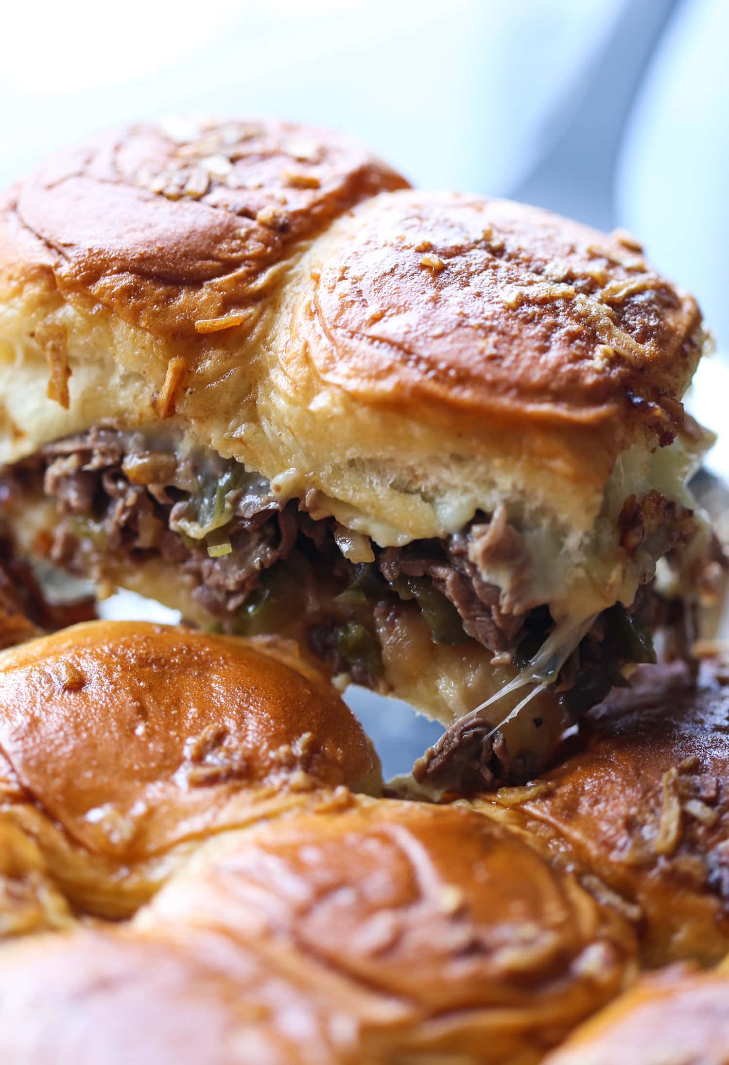 Se sacan dos deslizadores Philly cheesesteak de la sartén.