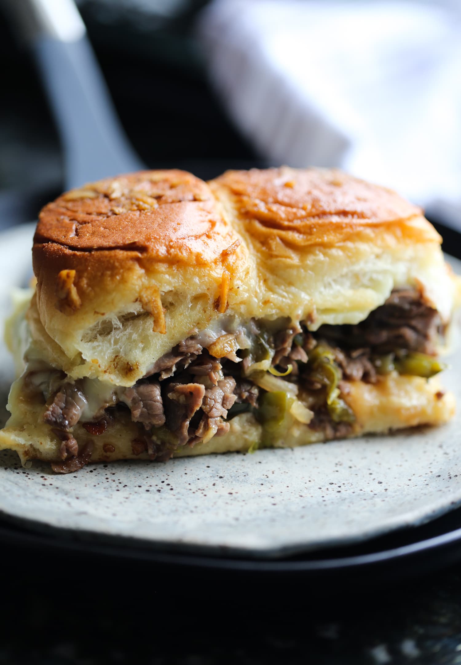 Dos deslizadores Philly cheesesteak en un plato.