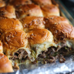 Deslizadores de bistec con queso Philly en una fuente para horno a la que le falta una fila.