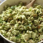 Ensalada de pollo diosa verde en un tazón grande con una cuchara de madera.
