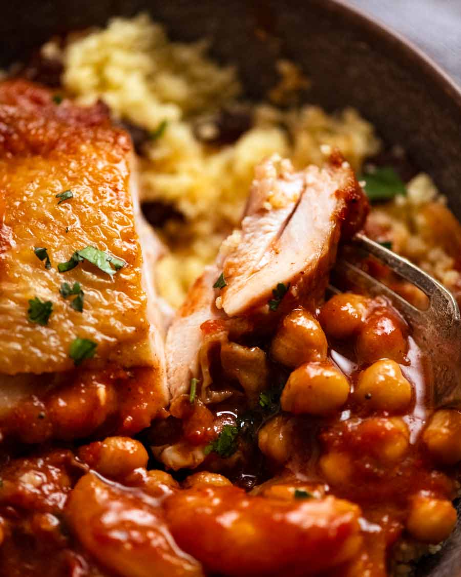 Primer plano de un trozo cortado de tajín de pollo marroquí servido con cuscús