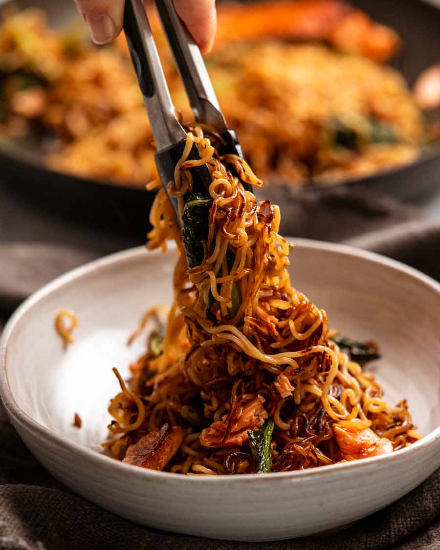 Sirviendo fideos de salmón teriyaki en un tazón