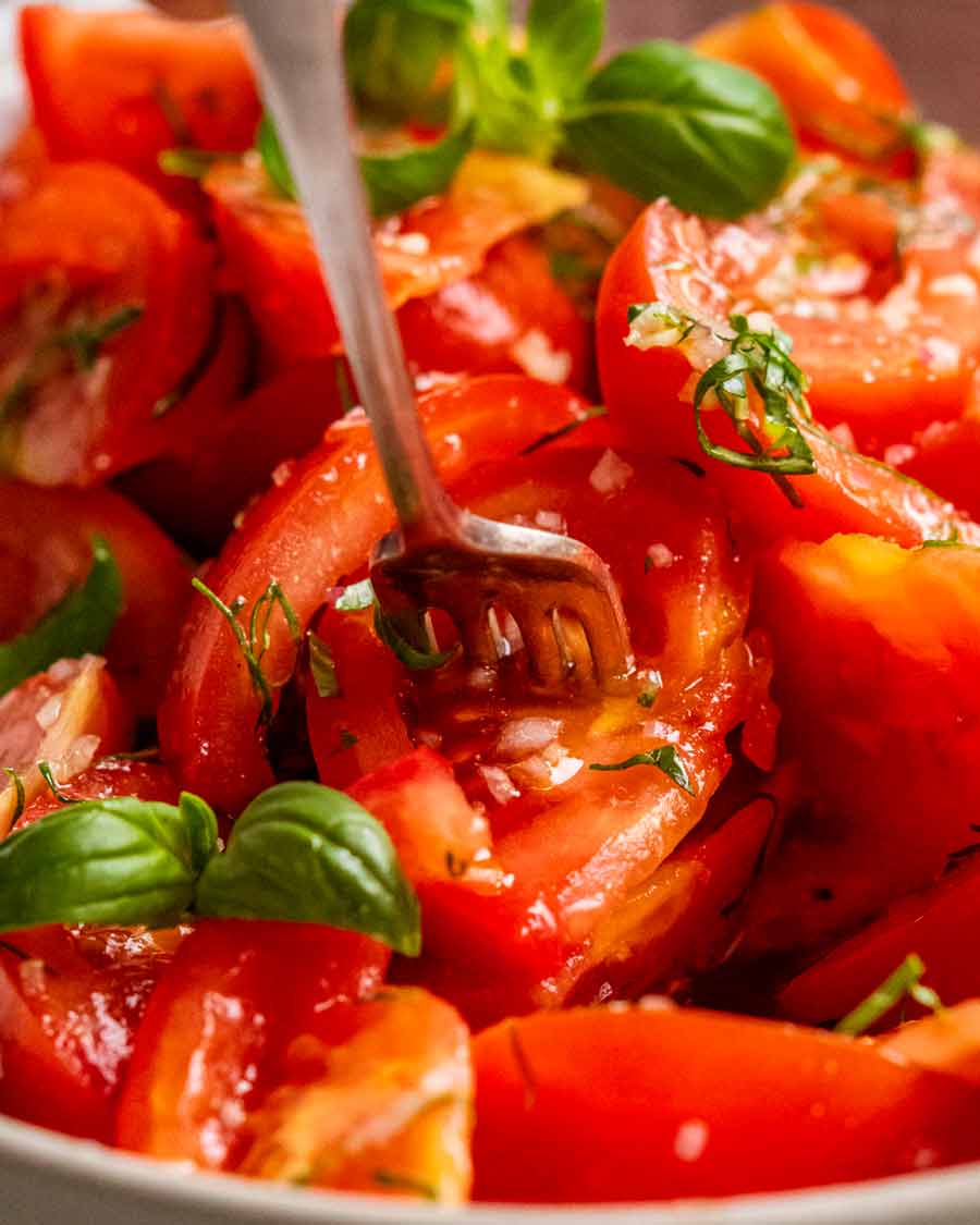 Primer plano de un tenedor recogiendo mi ensalada de tomate favorita