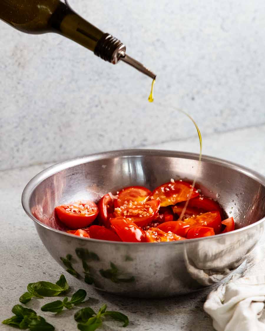 Rociar aceite sobre mi ensalada de tomate favorita