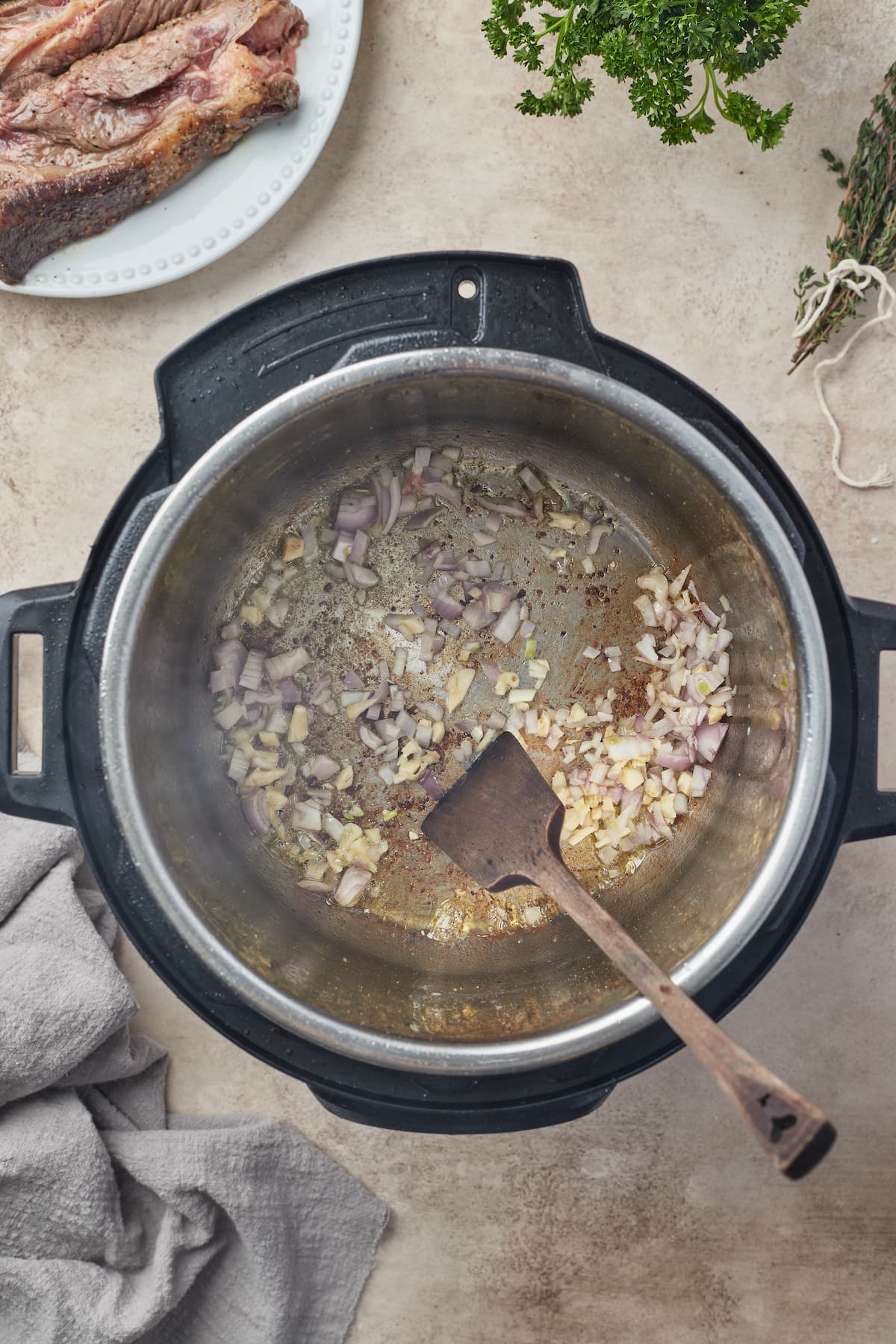 Las cebollas y el ajo se saltean en el tazón de una olla instantánea.