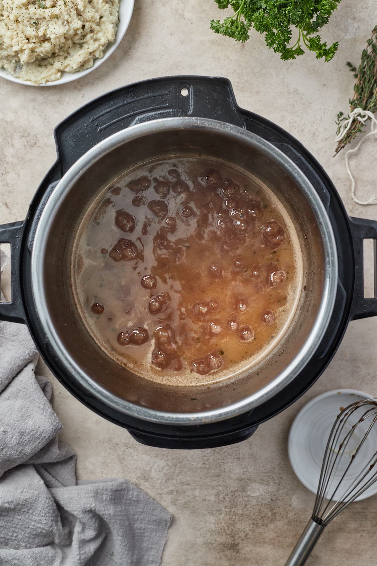 Salsa de vino tinto hirviendo a fuego lento dentro de Instant Pot para reducir.