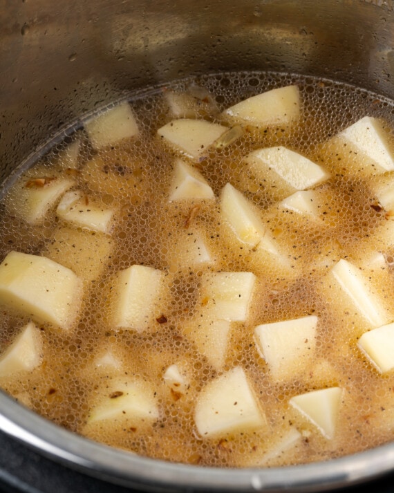 Papas y caldo hirviendo a fuego lento en Instant Pot.