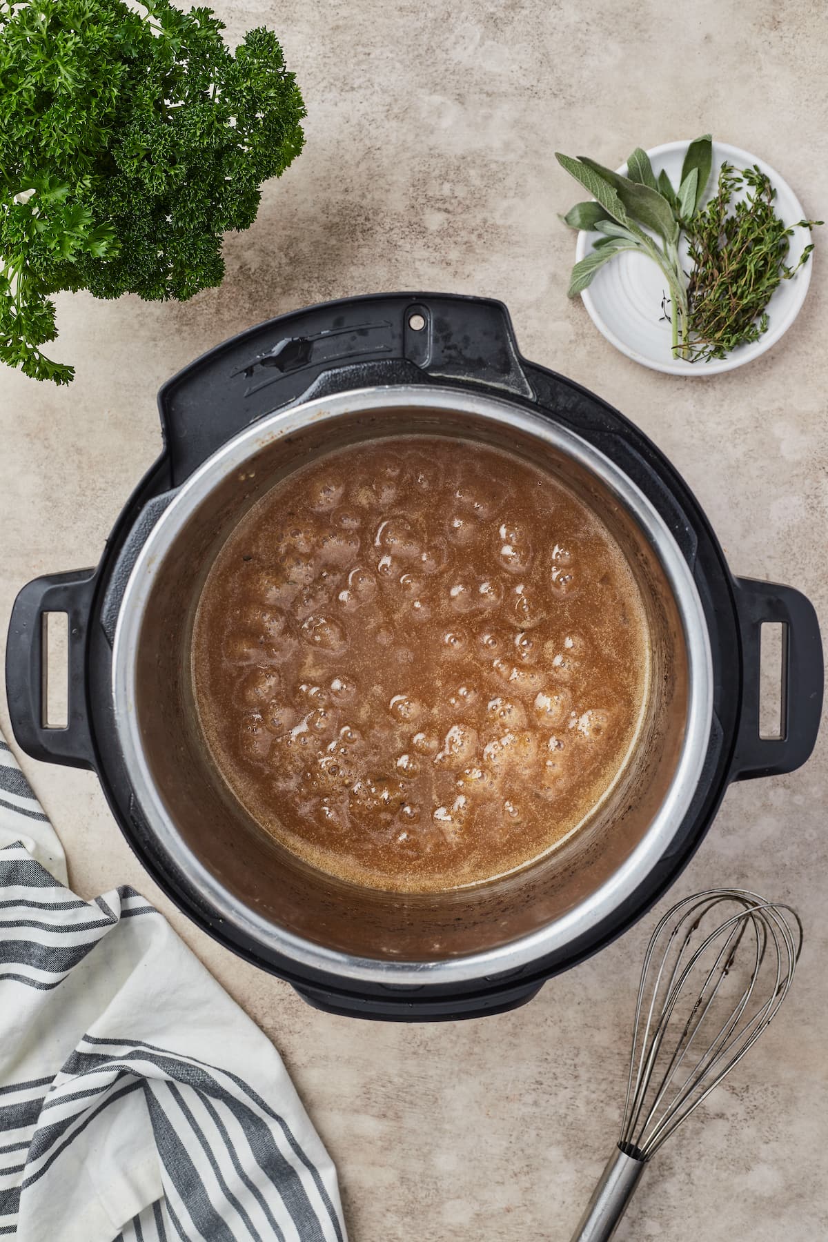 Carne de res en cubos hirviendo a fuego lento debajo de una capa de caldo de res en una olla instantánea.