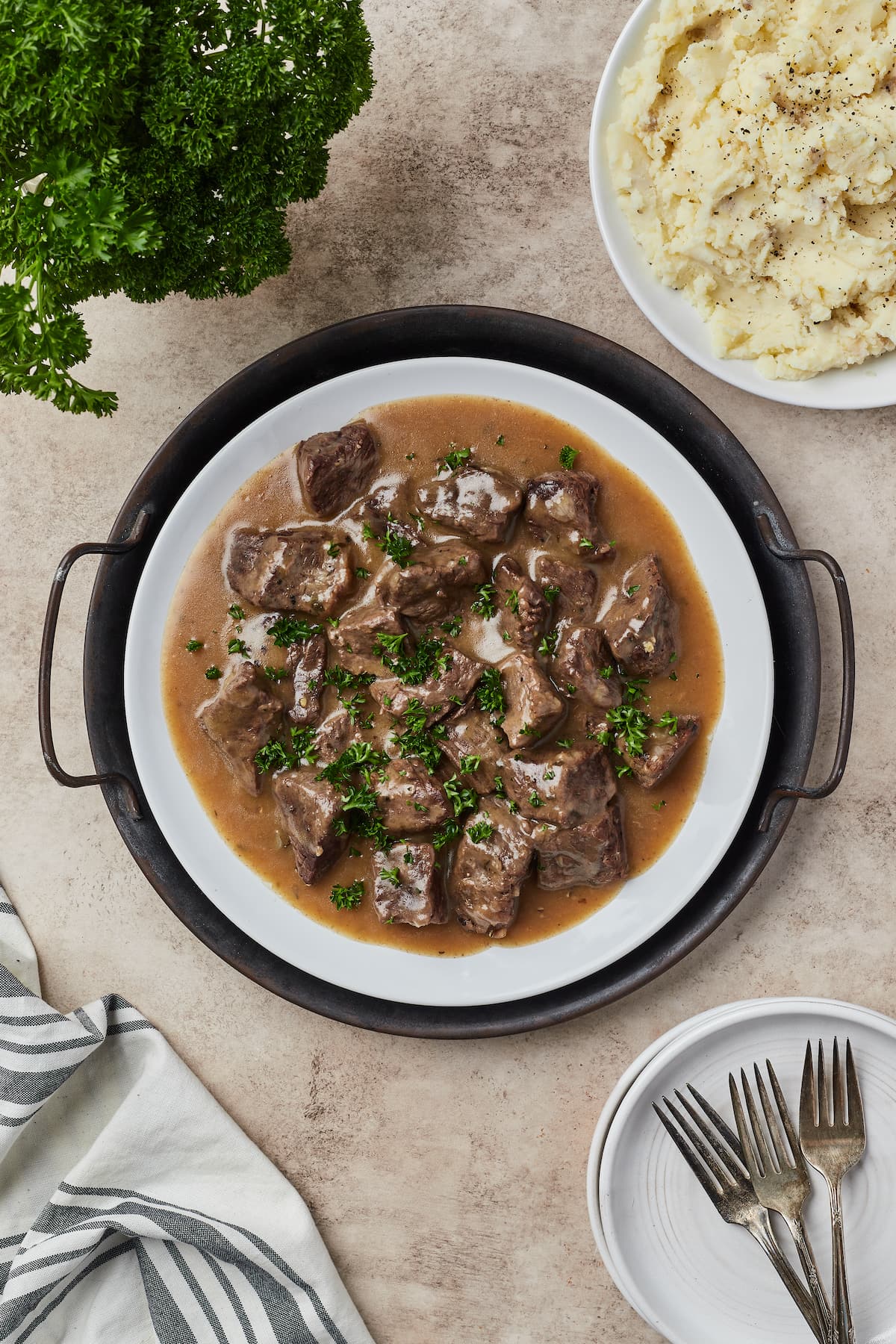 Vista superior de la carne de res en cubos cubierta con salsa en un plato redondo para servir.