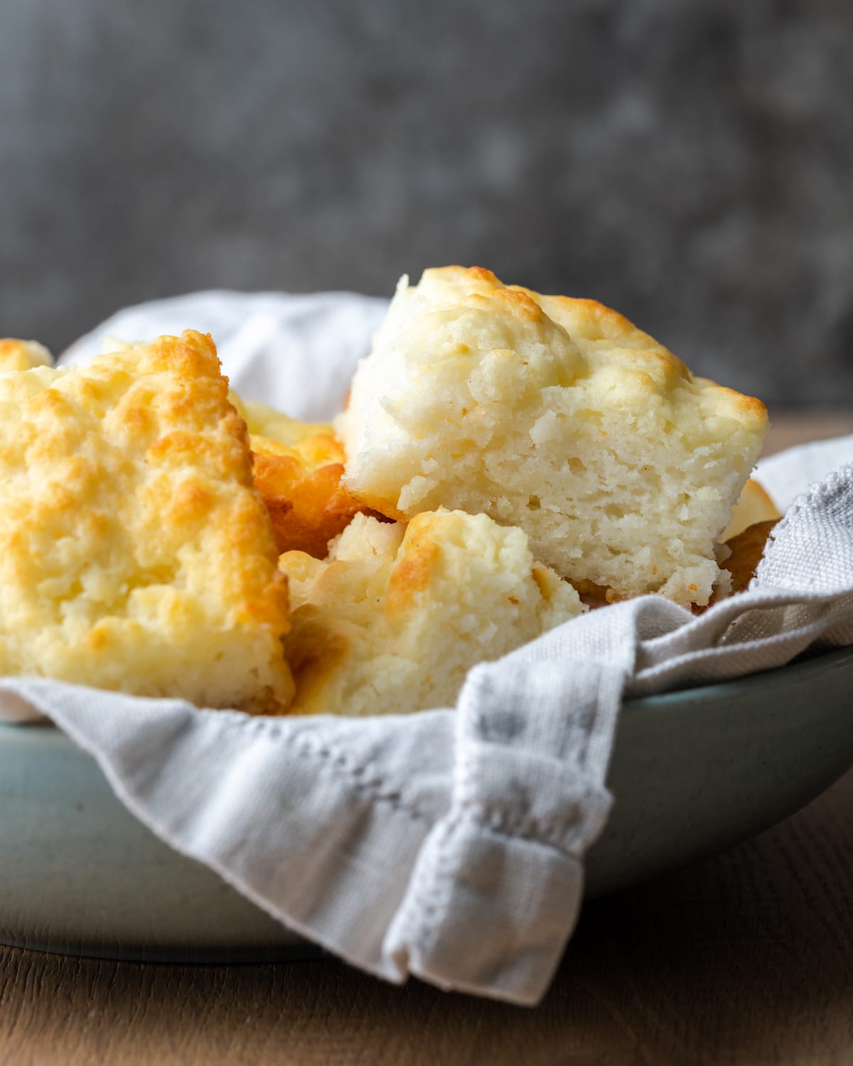¡Estas celestiales galletas Butter Swim se hornean doradas en mantequilla para obtener una textura increíblemente suave, húmeda y lista para rebanar! Galletas de mantequilla en un recipiente para servir forrado con un paño.
