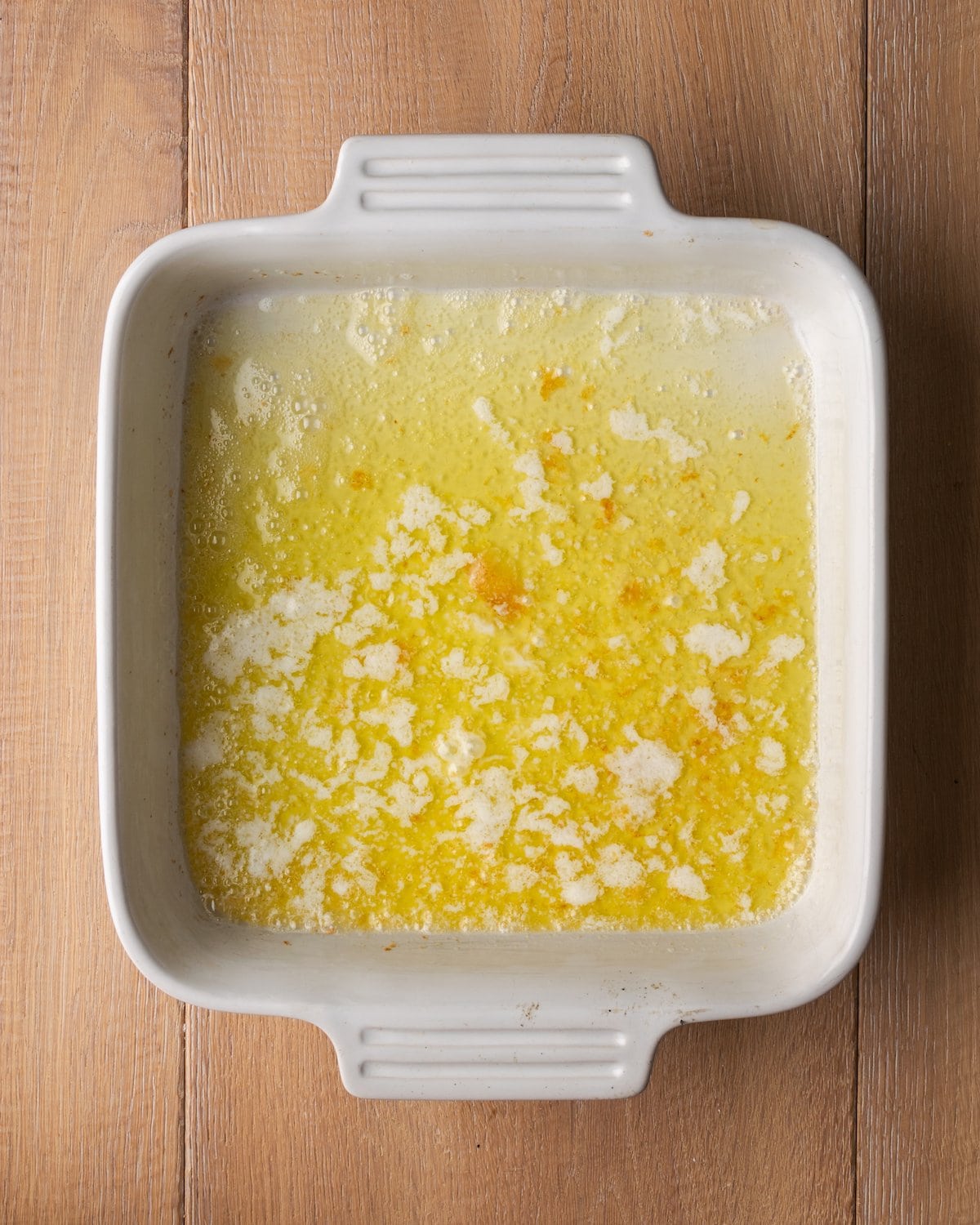 ¡Estas celestiales galletas Butter Swim se hornean doradas en mantequilla para obtener una textura increíblemente suave, húmeda y lista para rebanar! Mantequilla derretida en una fuente para horno cuadrada.