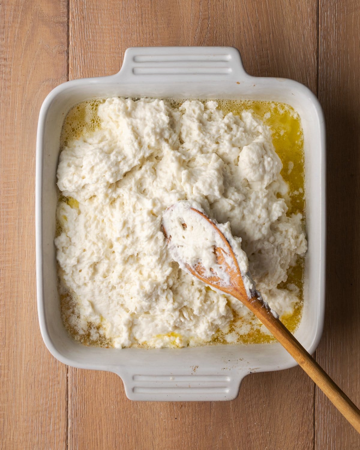 ¡Estas celestiales galletas Butter Swim se hornean doradas en mantequilla para obtener una textura increíblemente suave, húmeda y lista para rebanar! La masa de galletas se agrega sobre la mantequilla derretida en una fuente para hornear cuadrada.