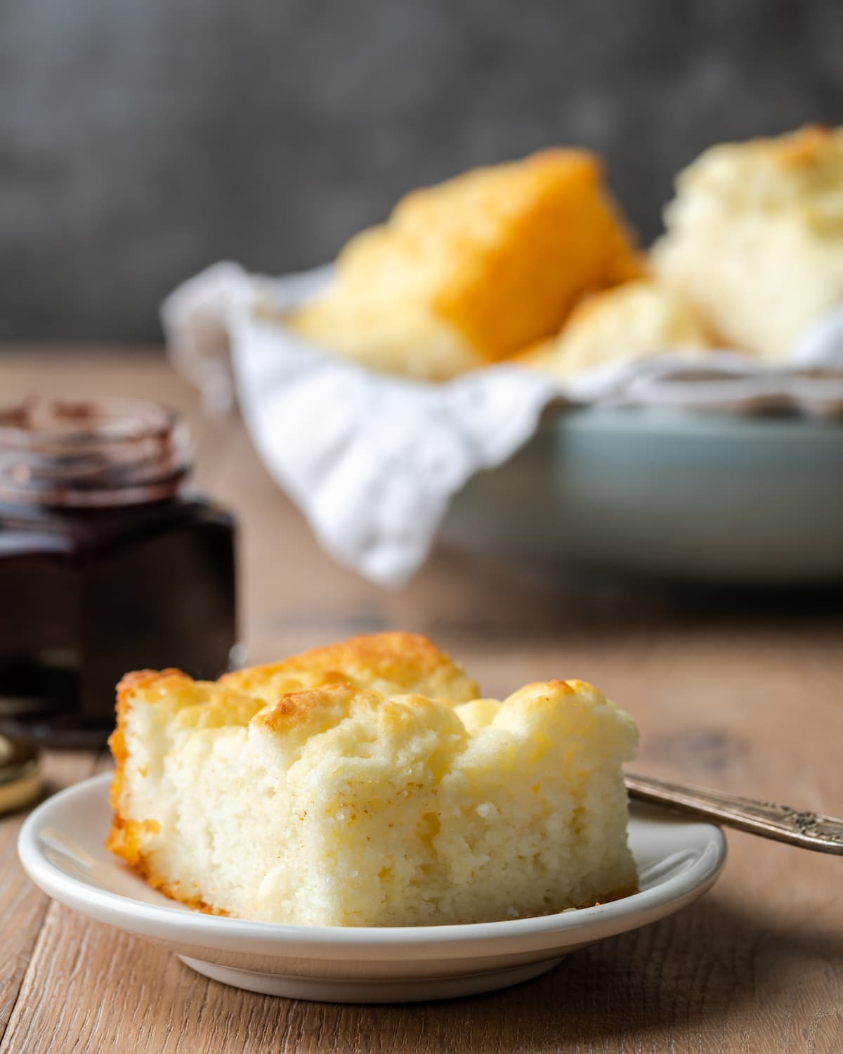 ¡Estas celestiales galletas Butter Swim se hornean doradas en mantequilla para obtener una textura increíblemente suave, húmeda y lista para rebanar! Una sola galleta en un plato blanco, con más galletas nadadoras de mantequilla en un tazón en el fondo.