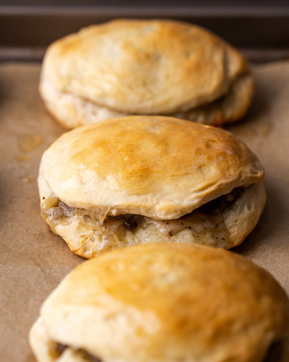 Tres galletas rellenas de filete de queso Philly seguidas.