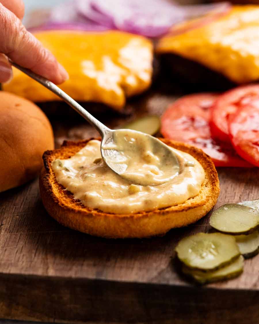 Untar salsa de hamburguesa especial para hamburguesas en un panecillo