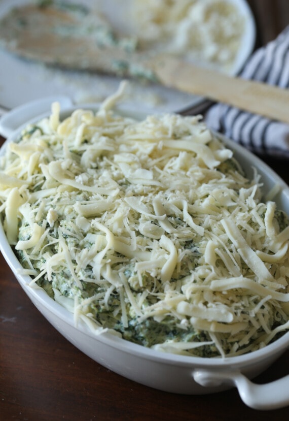 Dip de espinacas y alcachofas cubierto con una capa de queso rallado.
