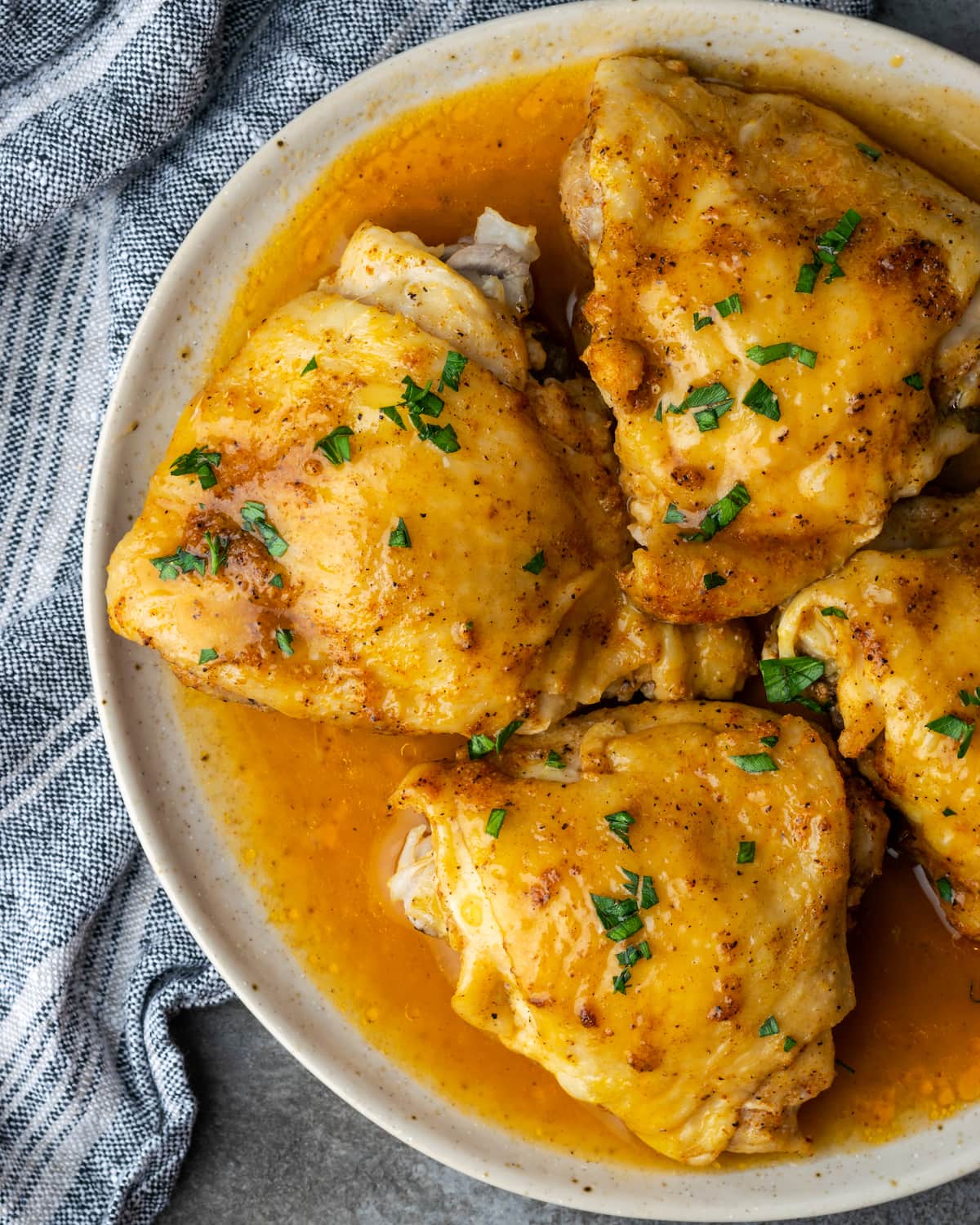 Vista superior de muslos de pollo instantáneos en un plato cubierto con salsa.