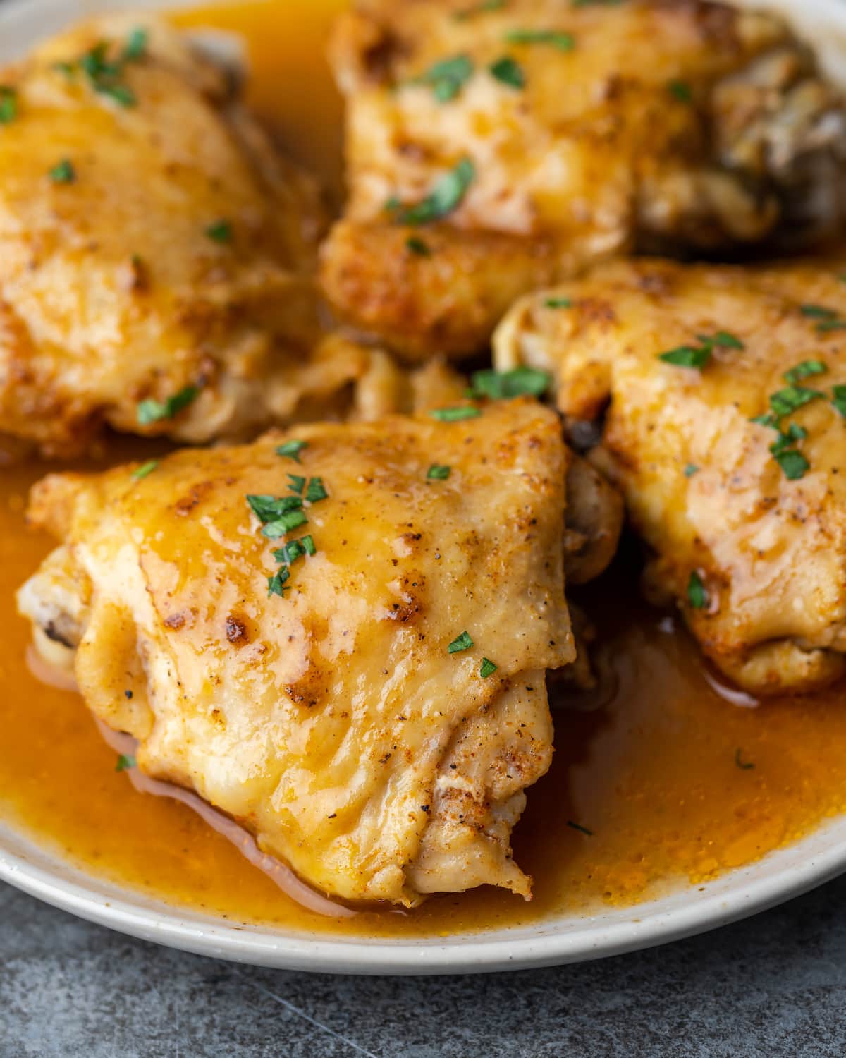Cerca de muslos de pollo instantáneos en un plato cubierto con salsa.