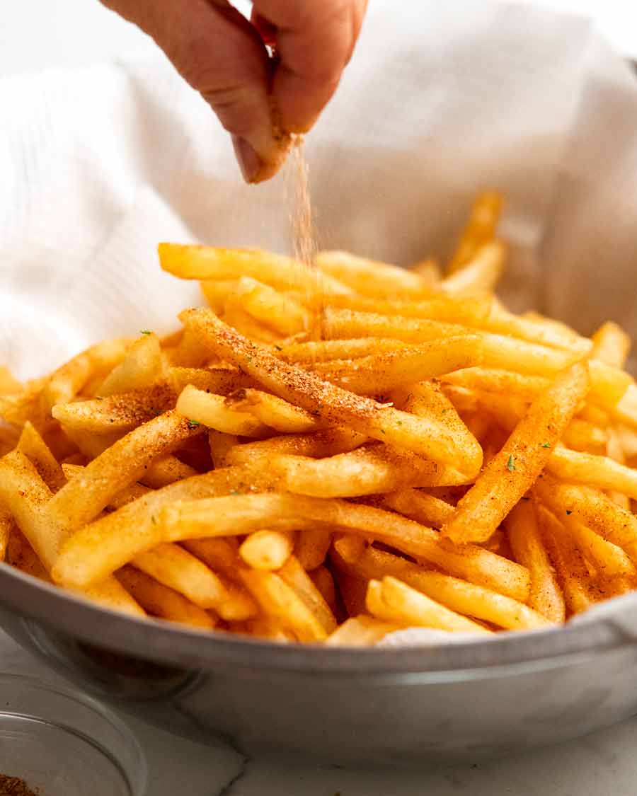 Espolvorear condimento de papas fritas sobre papas fritas