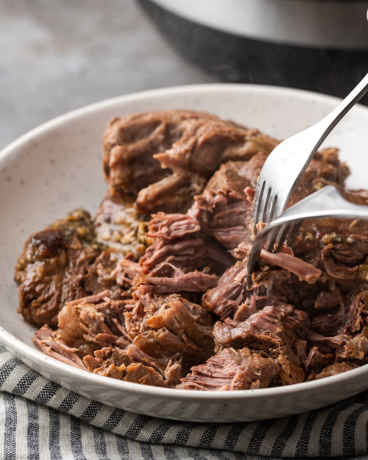 Se usa un tenedor para separar la carne cocida para el asado a la olla Mississippi.