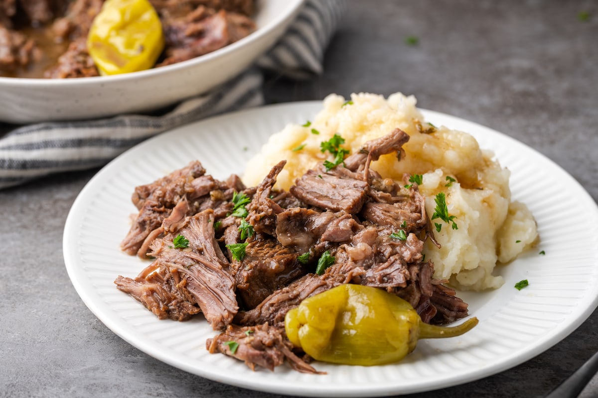 Asado a la olla de Mississippi en un plato blanco junto al puré de papas.