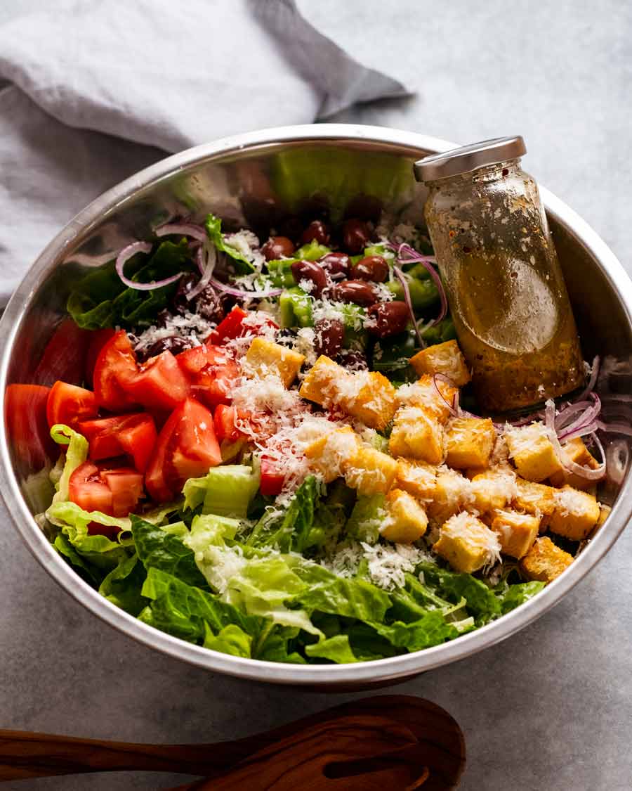 Ingredientes de la Mega Ensalada Italiana en un tazón listos para ser arrojados