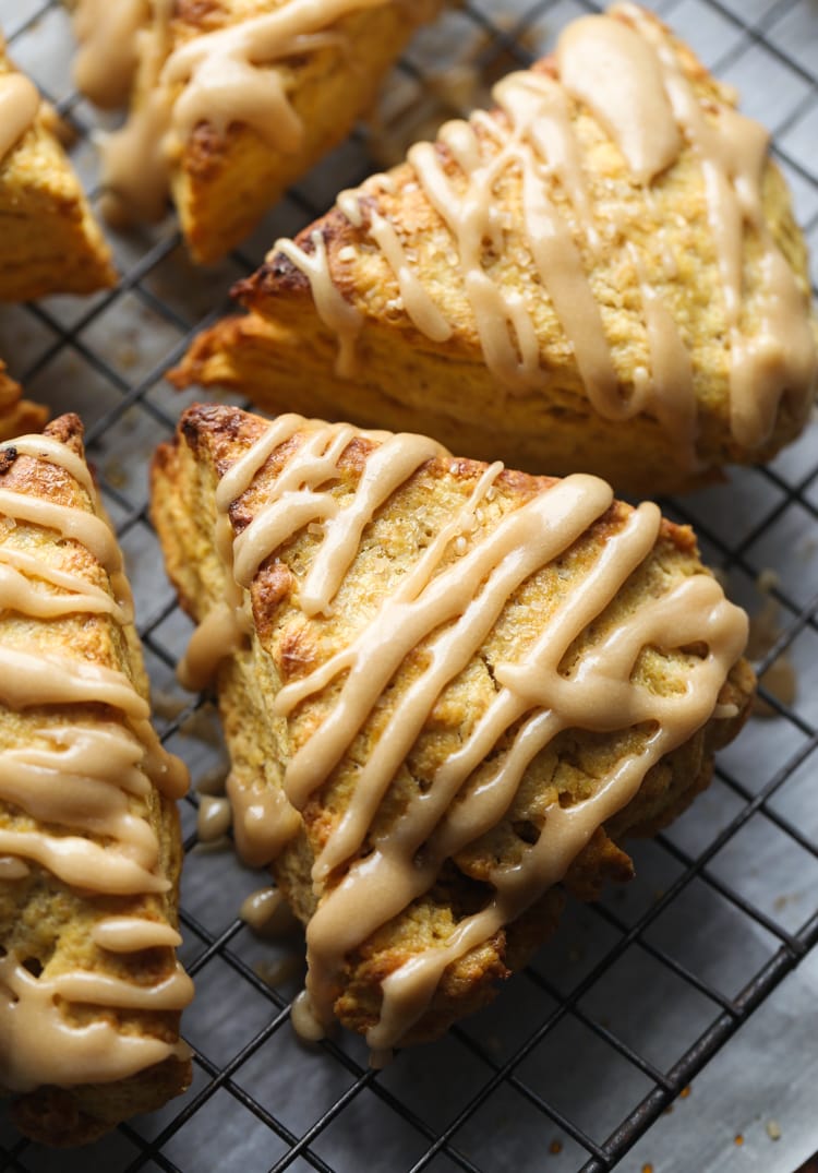Scones de calabaza con glaseado de azúcar moreno en una rejilla para enfriar.