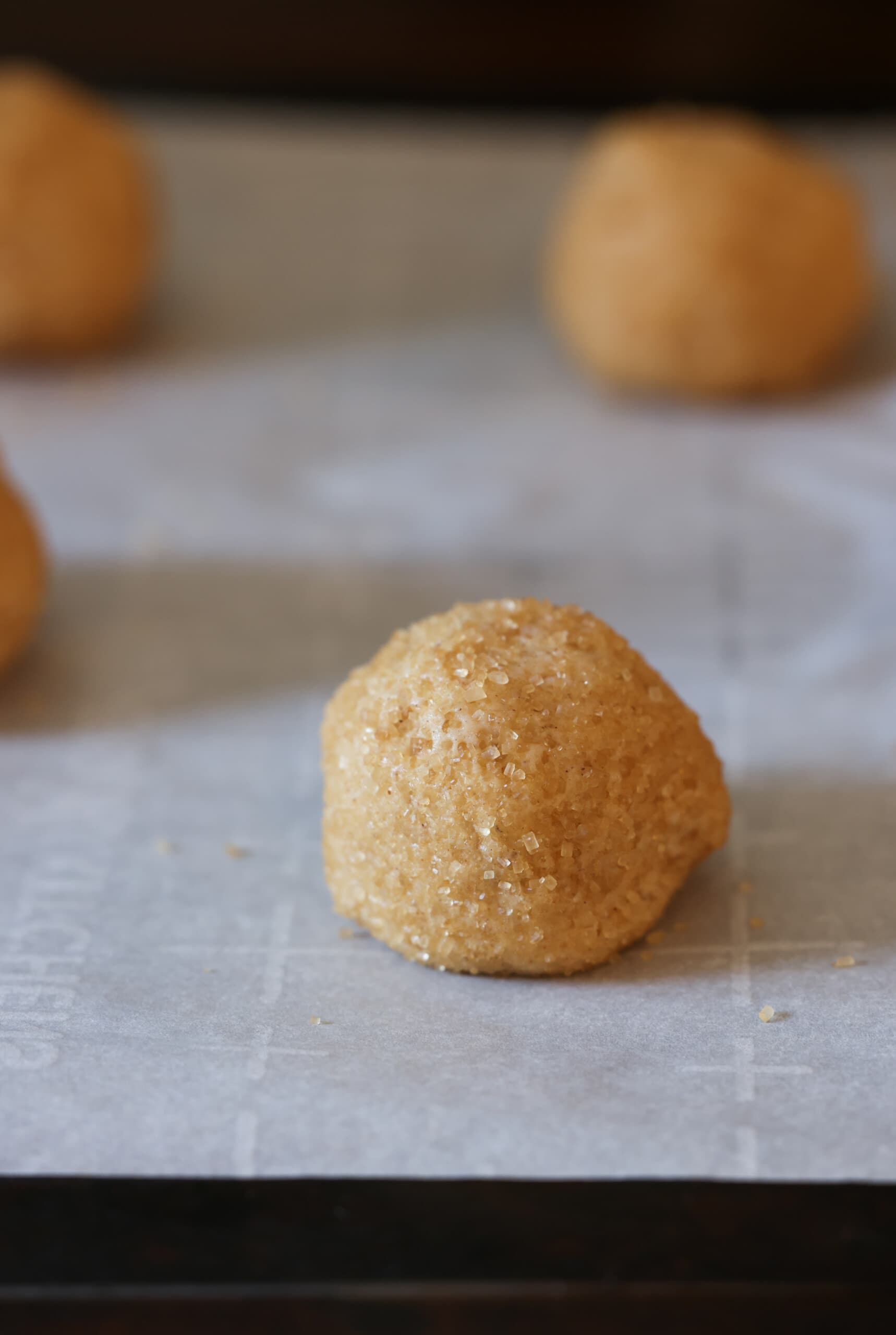 masa para galletas enrollada en azúcar gruesa en una bandeja para hornear