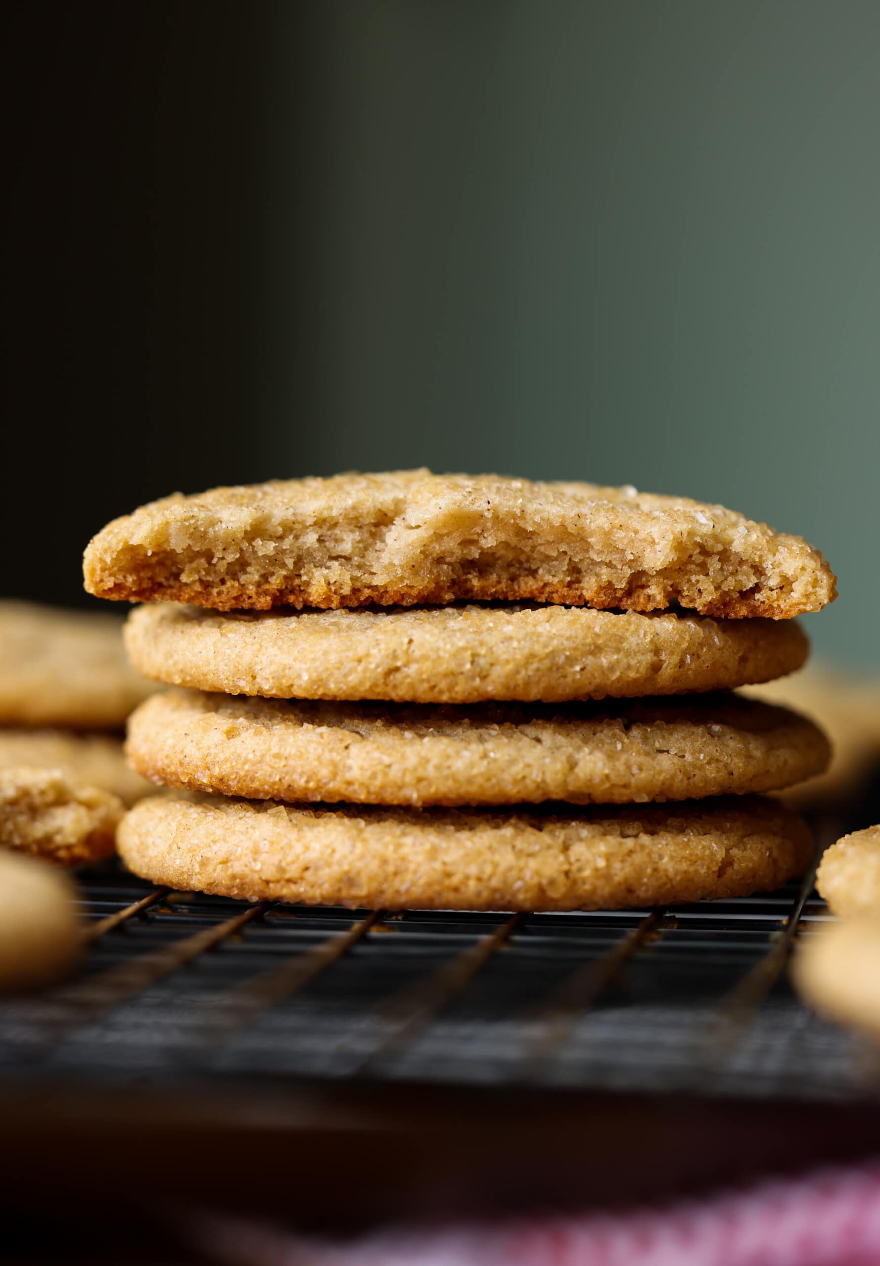 ¡Las galletas de sidra de manzana caseras son masticables y dulces hechas al reducir el jarabe de sidra de manzana en la parada para obtener el máximo sabor a sidra en su galleta! pila de galletas de manzana con una rota por la mitad