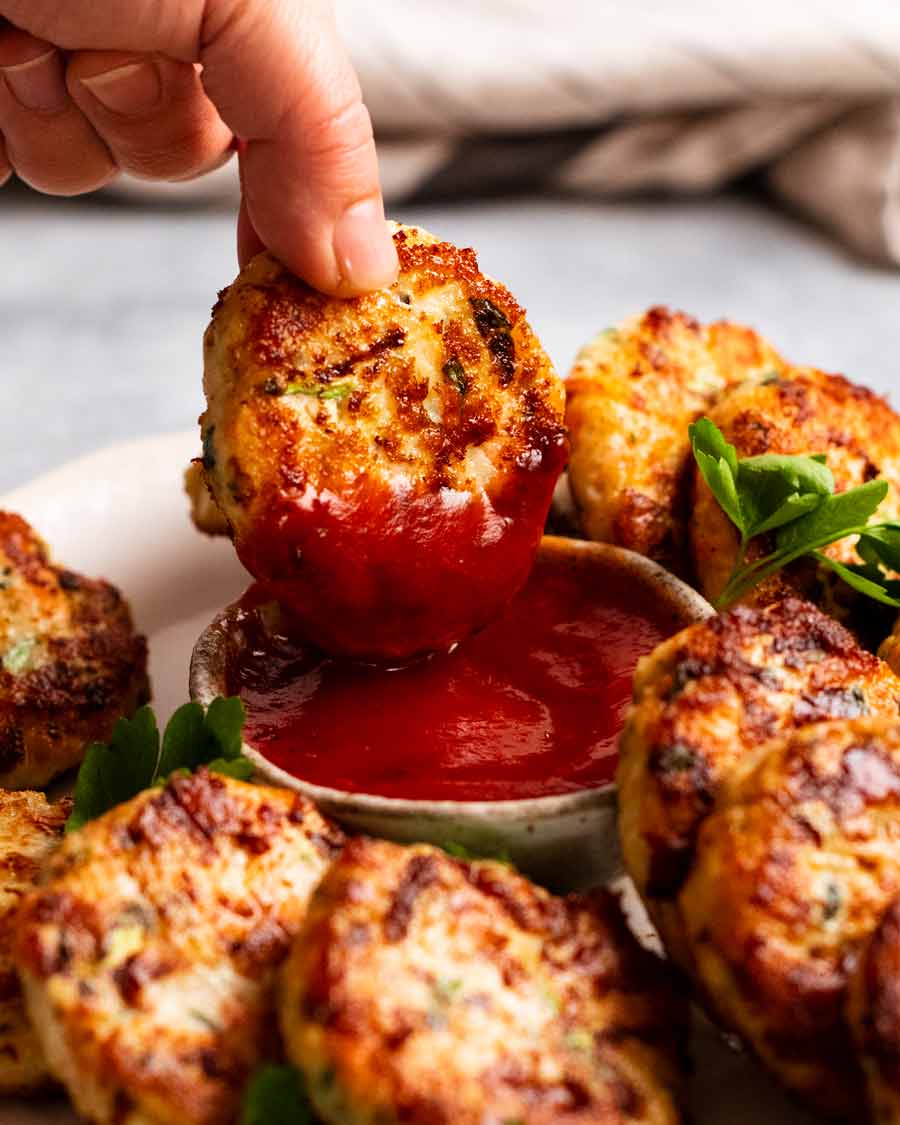 Mojar una albóndiga de pollo en ketchup