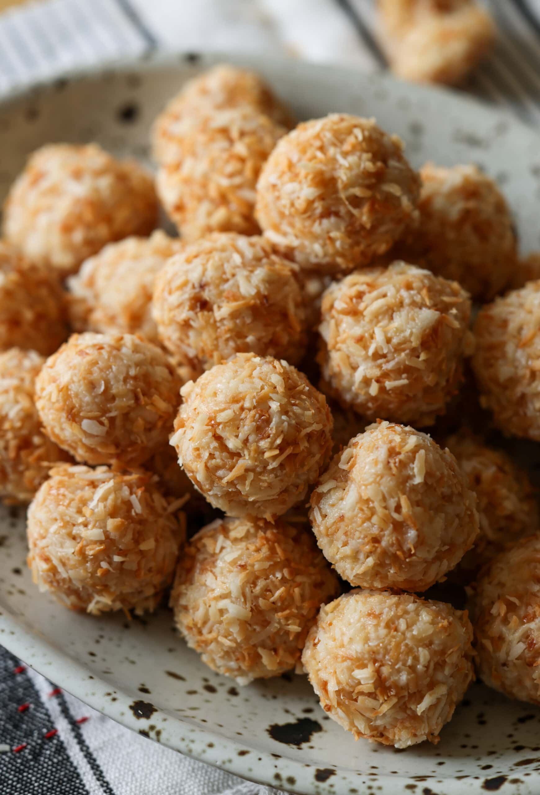 Bolas de coco enrolladas en coco tostado en un plato