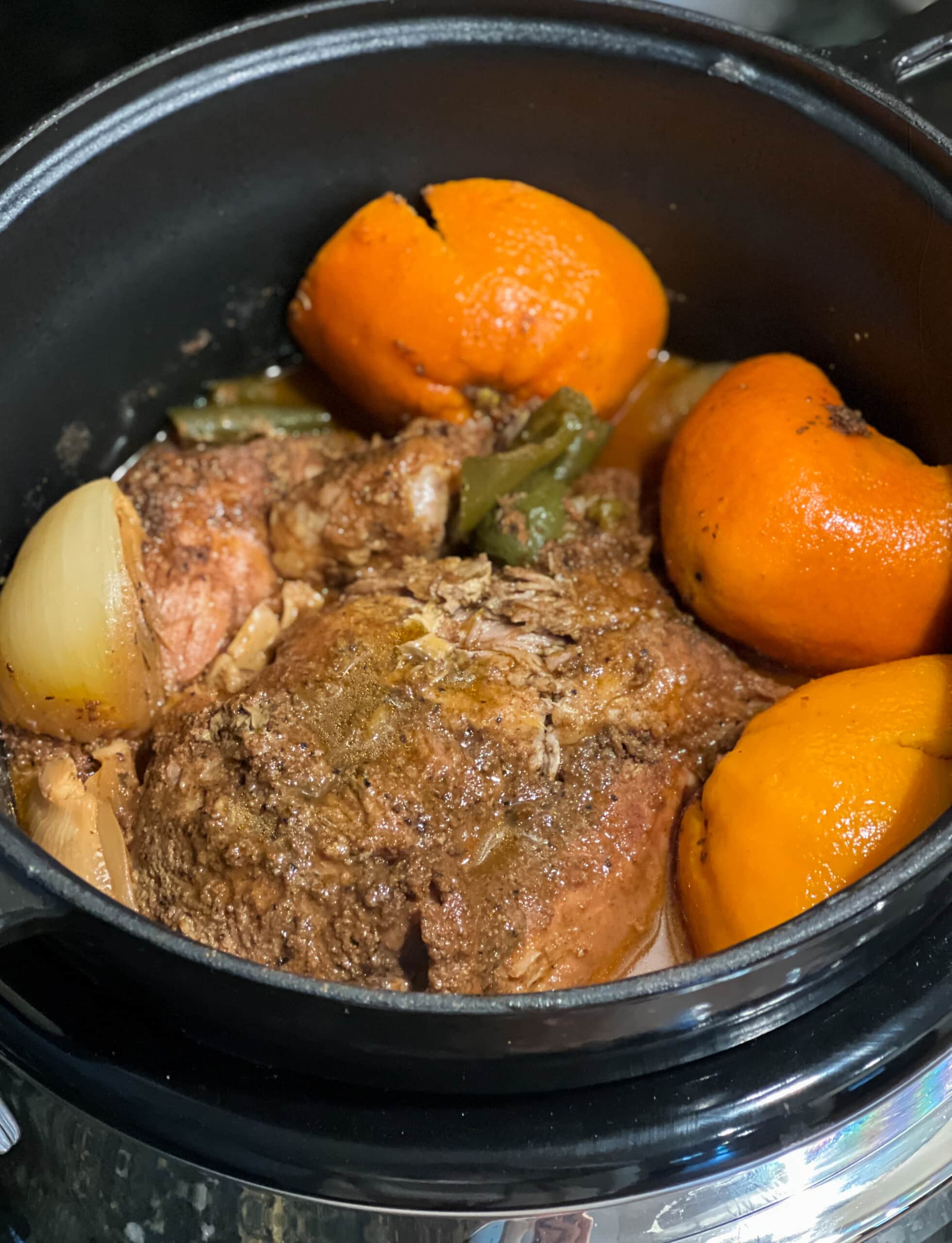 ingredientes de carnitas de cerdo en una olla de cocción lenta antes de cocinar