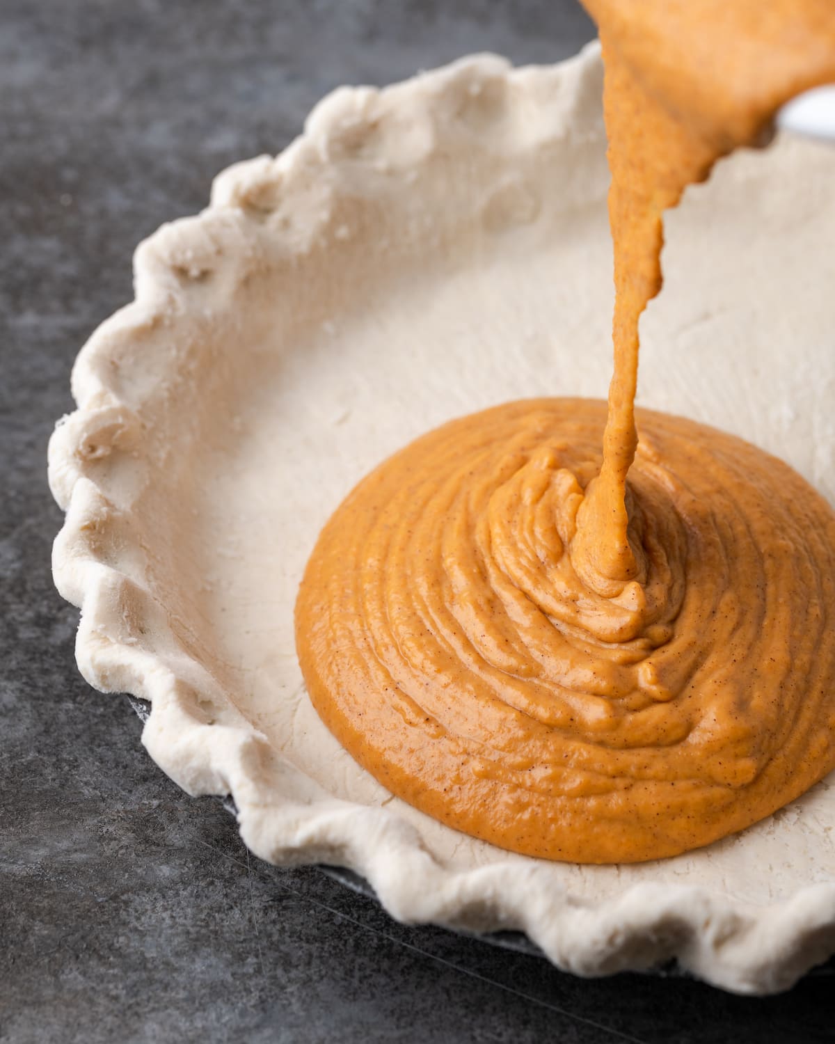 El relleno de pastel de calabaza se vierte en una masa de pastel.