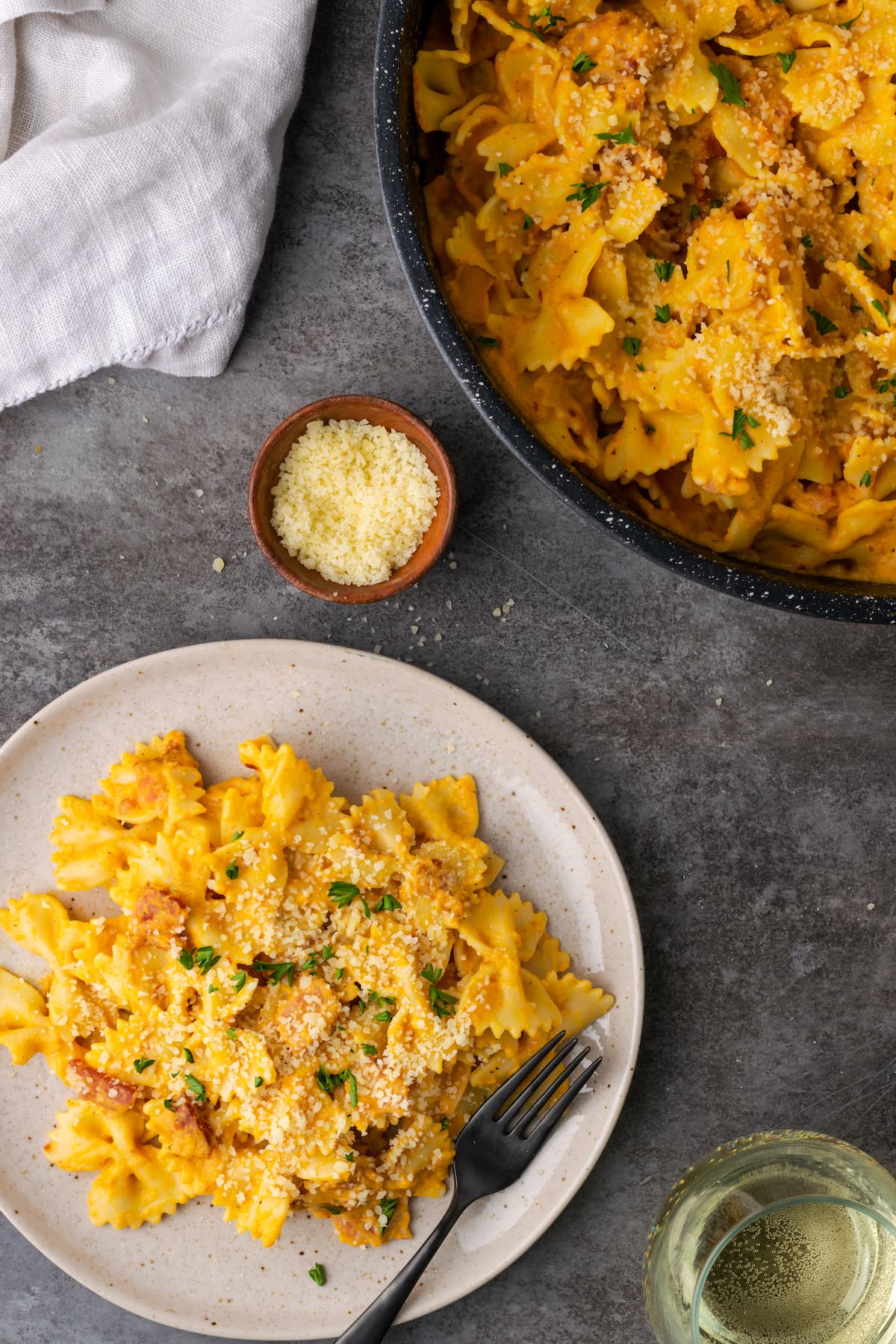 Un plato de pasta de calabaza con tocino junto a un tazón negro lleno de pasta de calabaza.