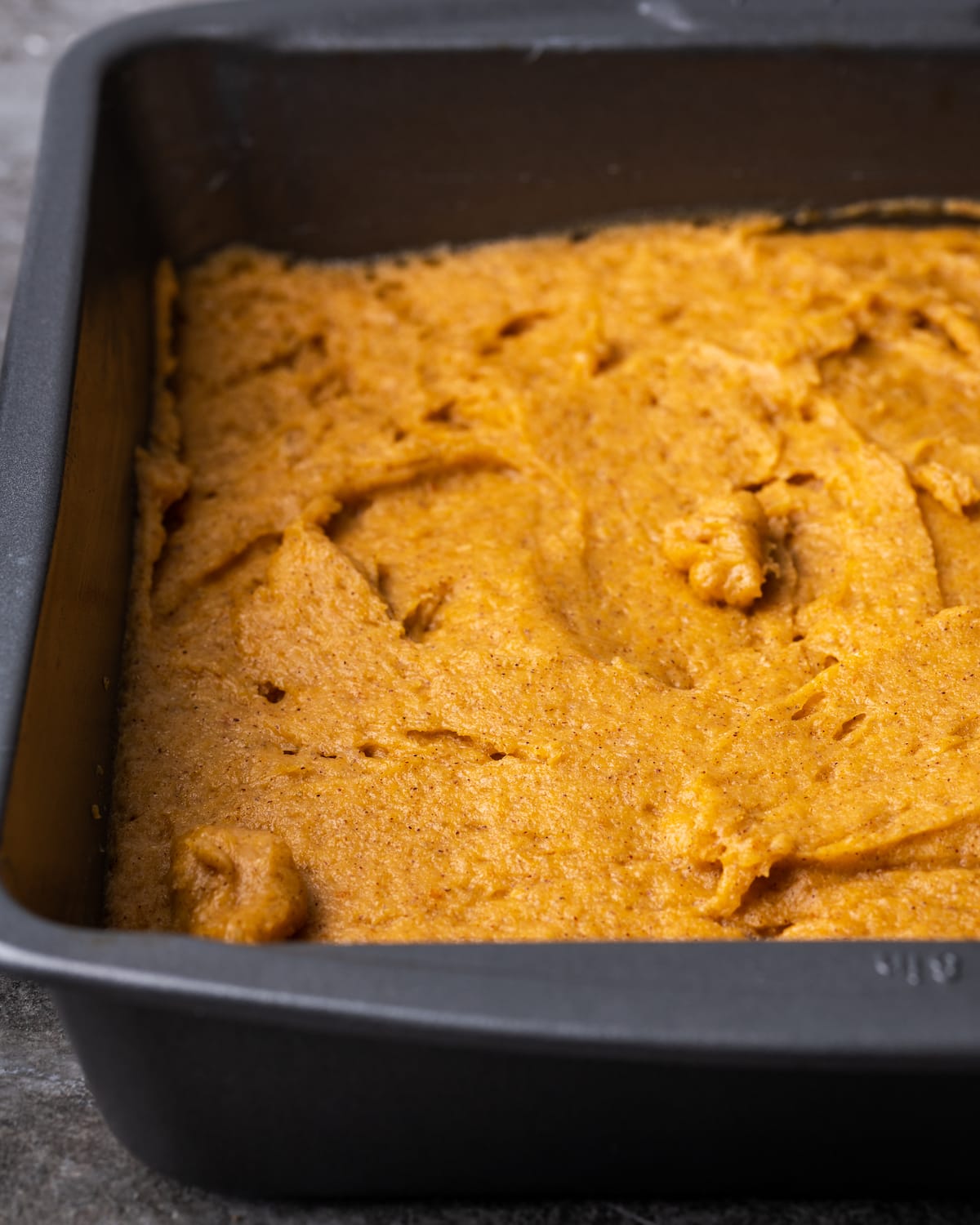Masa de pastel de calabaza en una fuente de horno de metal.