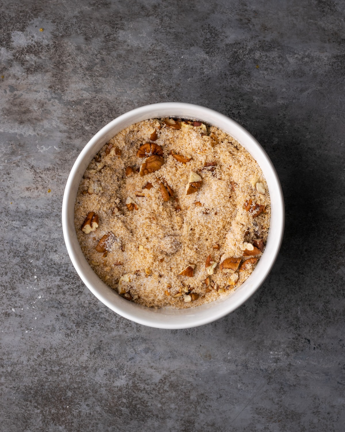 Nueces tostadas combinadas con azúcar moreno y blanco en un bol.