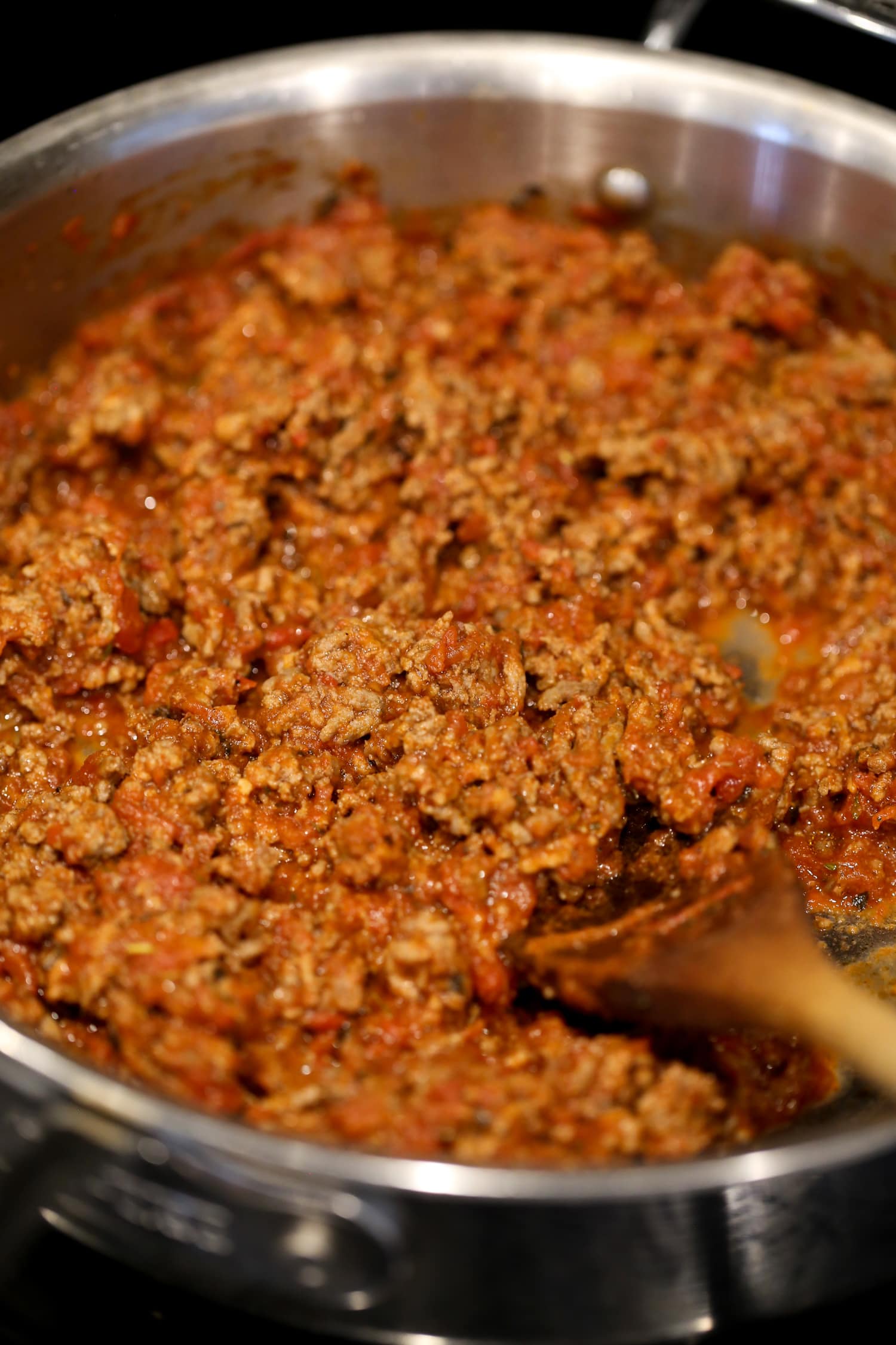 Salsa de carne en una olla con una cuchara de madera.