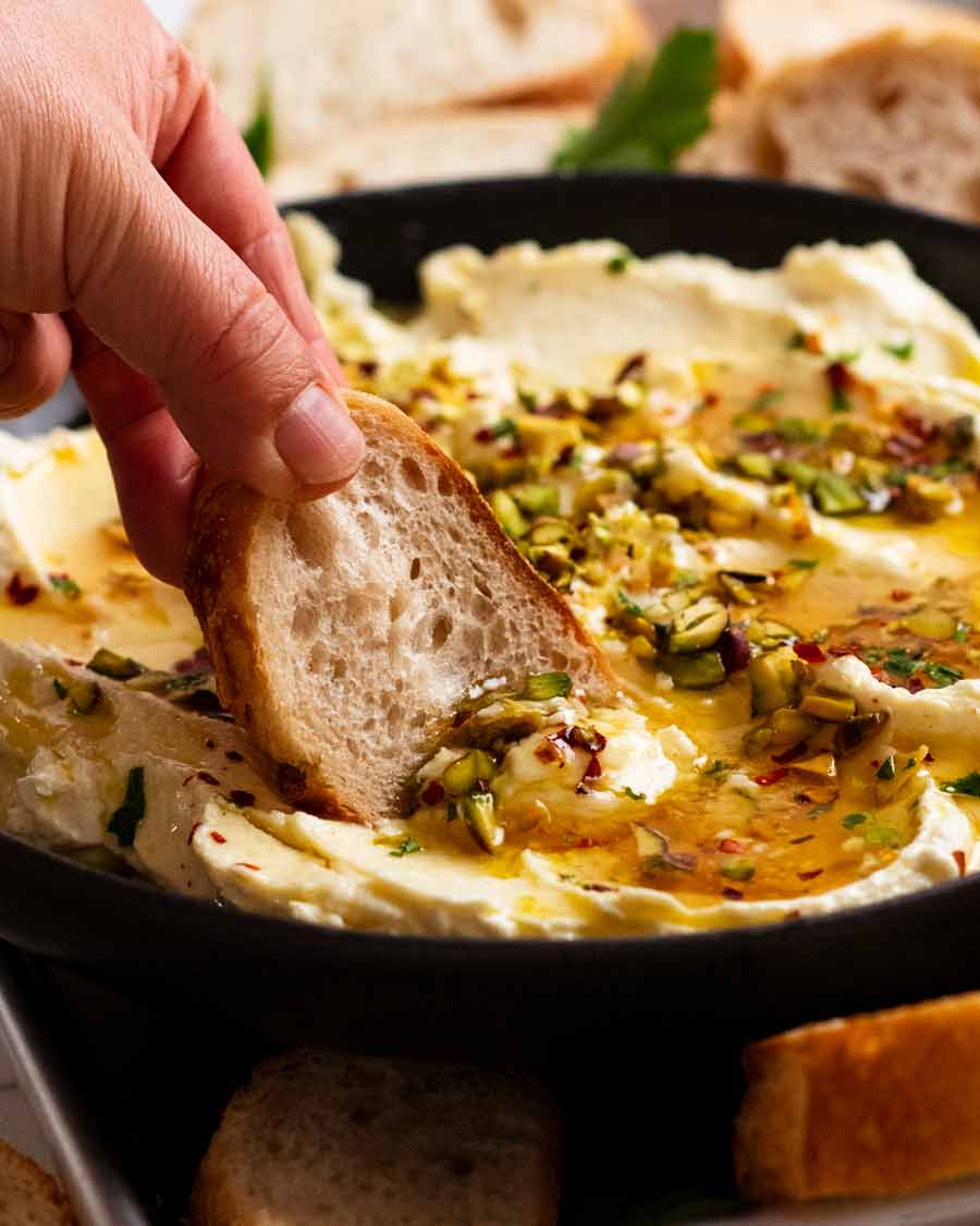 Sumergir el pan en la salsa cremosa de queso feta