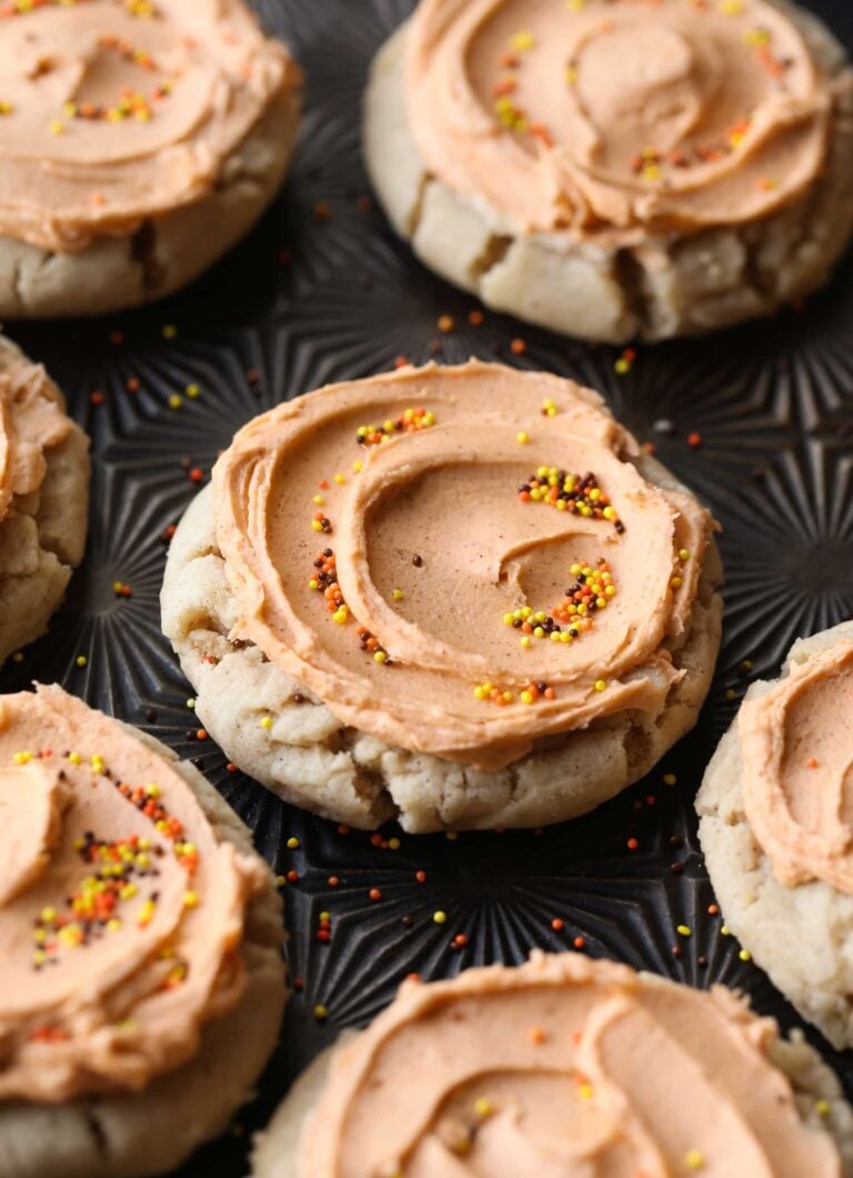 Galletas de azúcar con especias de calabaza en una bandeja cubierta con glaseado de mantequilla dorada y chispas