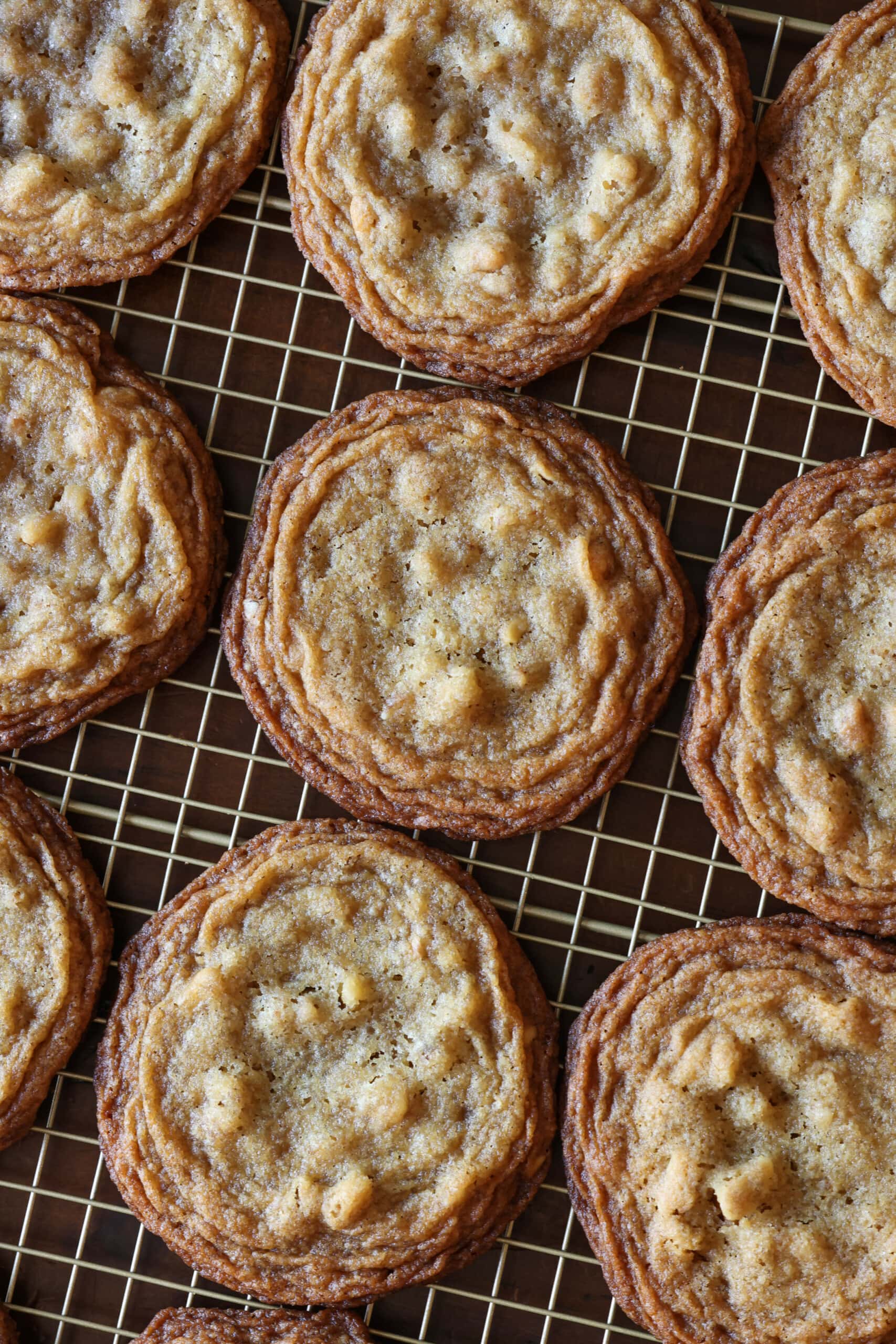 Estas galletas de nuez ultra masticables están hechas con dos tipos de azúcar, un método de golpear la sartén que le da bordes crujientes y mantecosos con centros masticables. Galletas masticables de nuez en una rejilla para enfriar