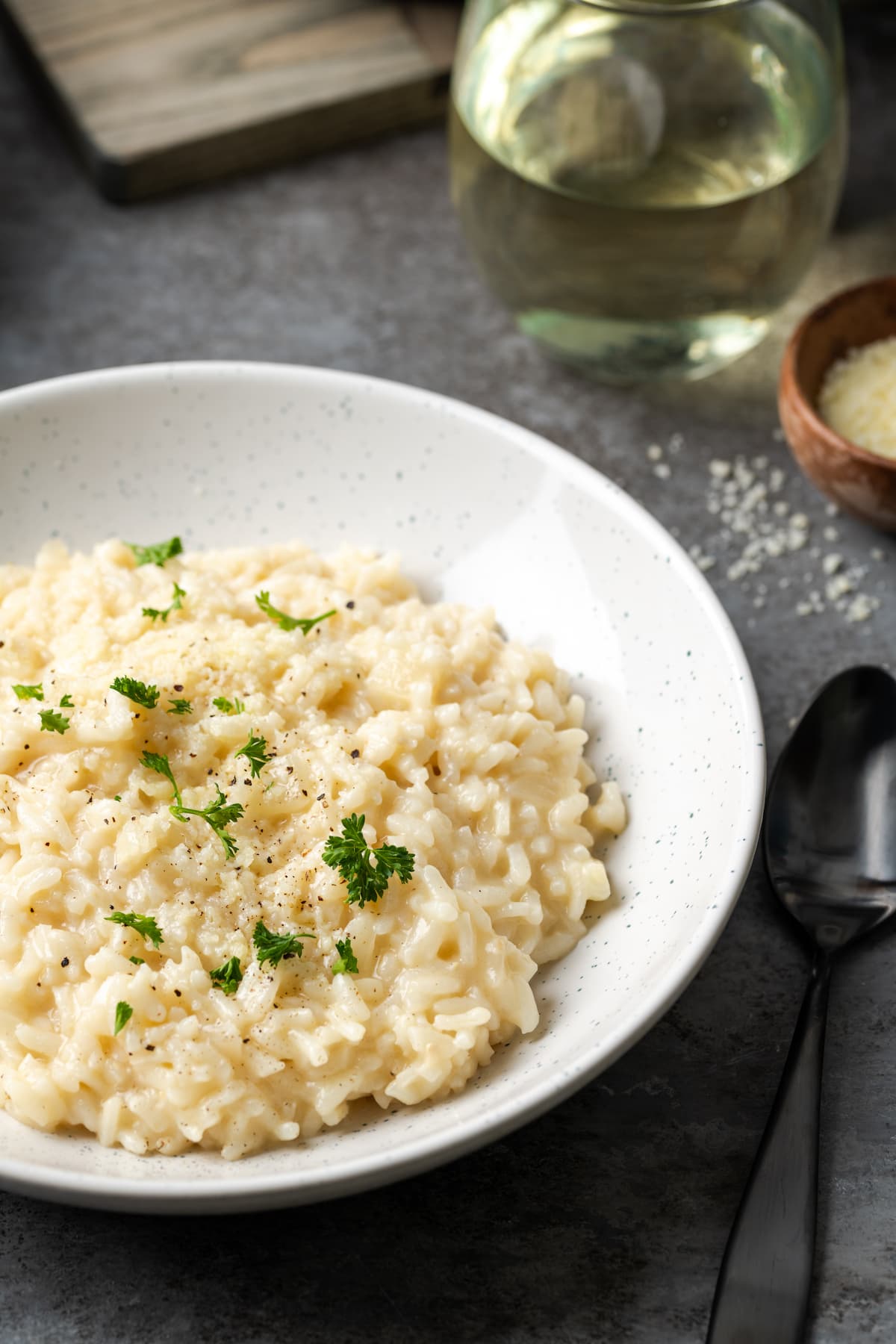 Esta receta de Instant Pot Risotto es un plato principal o guarnición fácil que es tan rico y cremoso como el risotto clásico, ¡y está listo en 30 minutos! Un tazón de cremoso risotto Instant Pot adornado con perejil fresco.