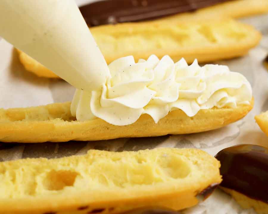 Tubería de crema batida en un eclair