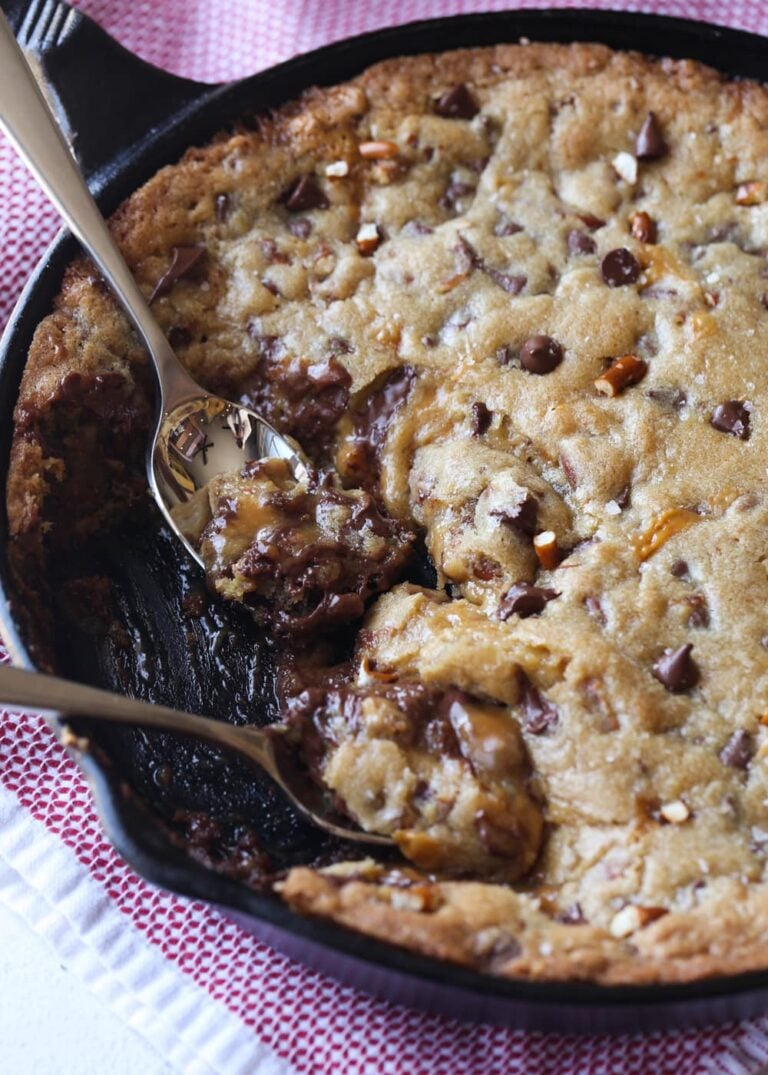 Comer pizookie de caramelo salado de la sartén con cucharas