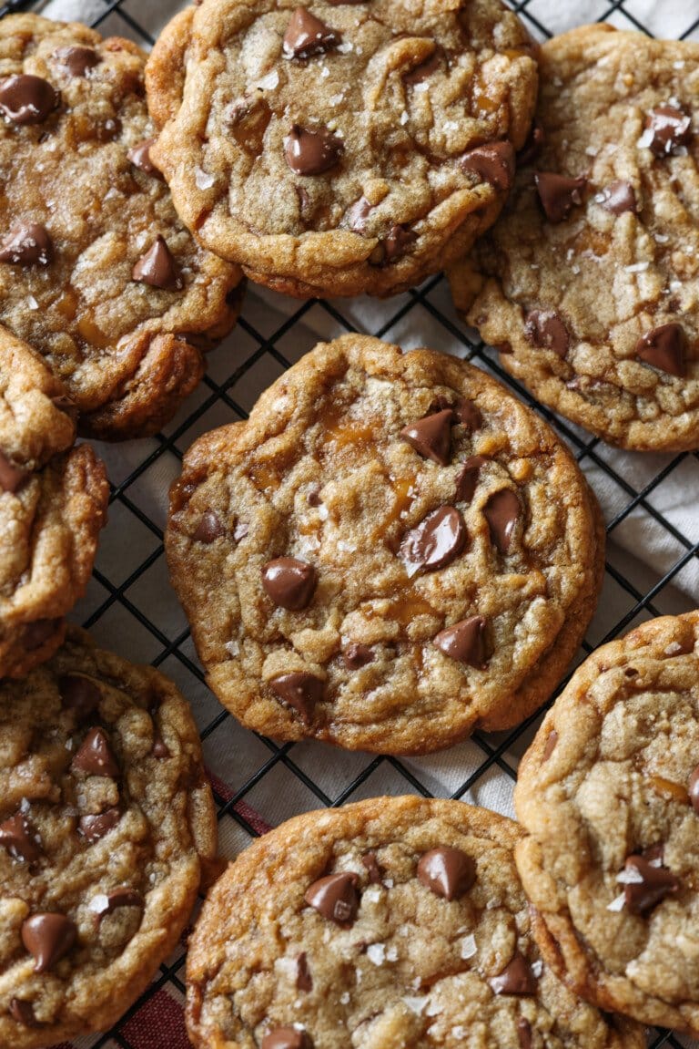 galletas de chispas de chocolate crujientes de mantequilla en una rejilla con sal marina en copos