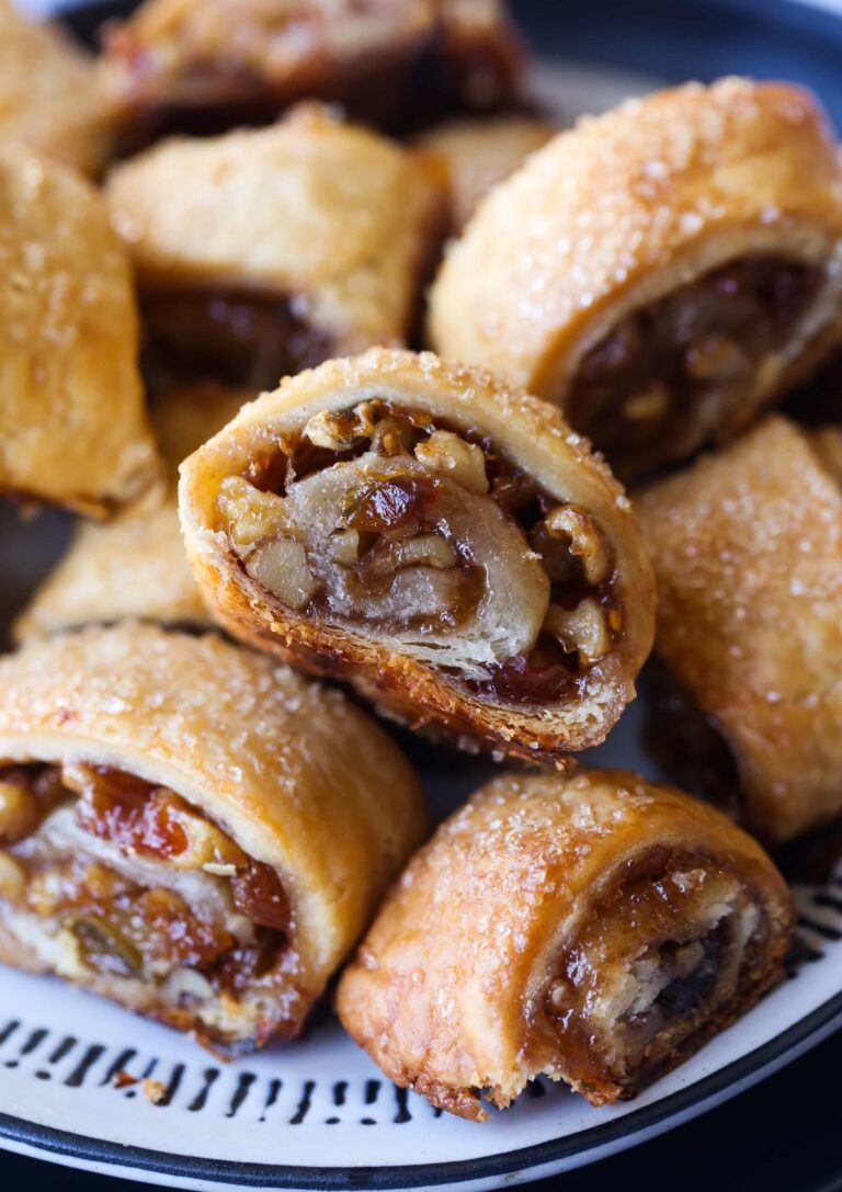 Surtido de galletas Rugelach rellenas de nueces y frutas en un plato.