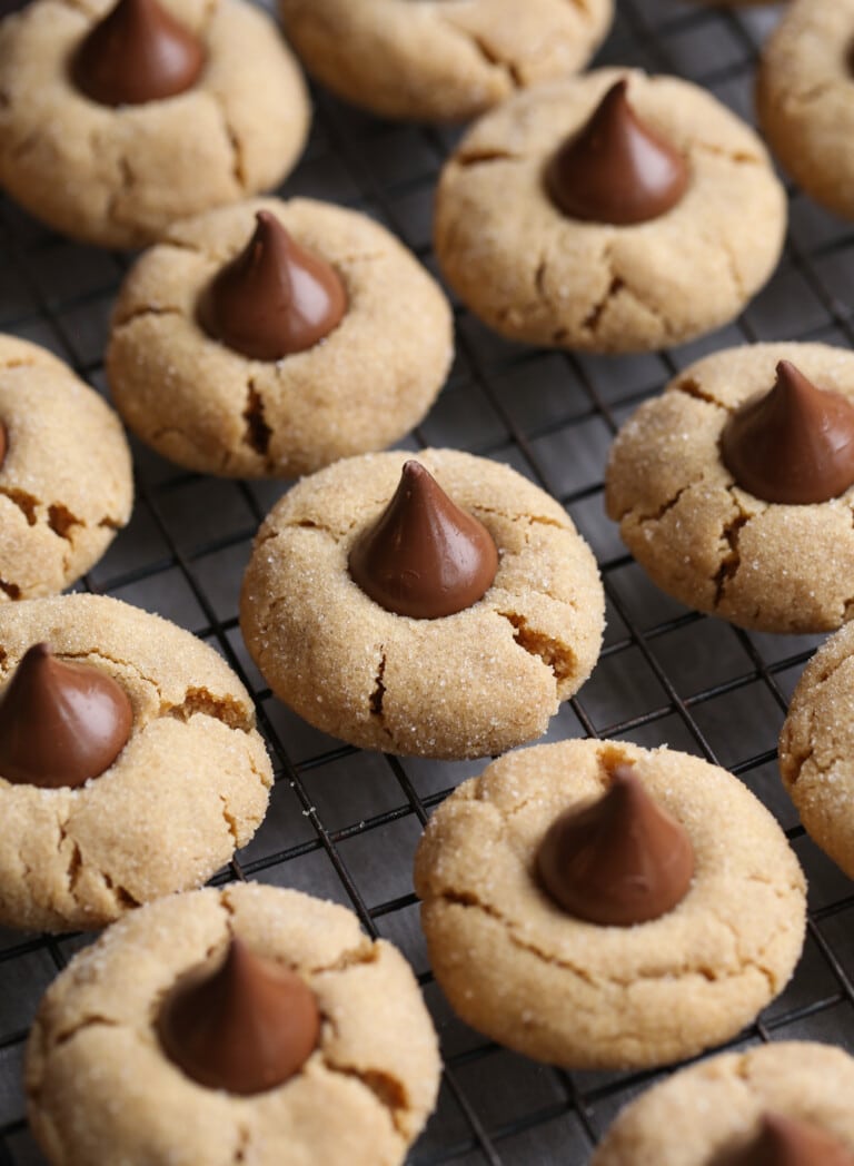 Galletas de flor de mantequilla de maní alineadas en filas en una rejilla de alambre.