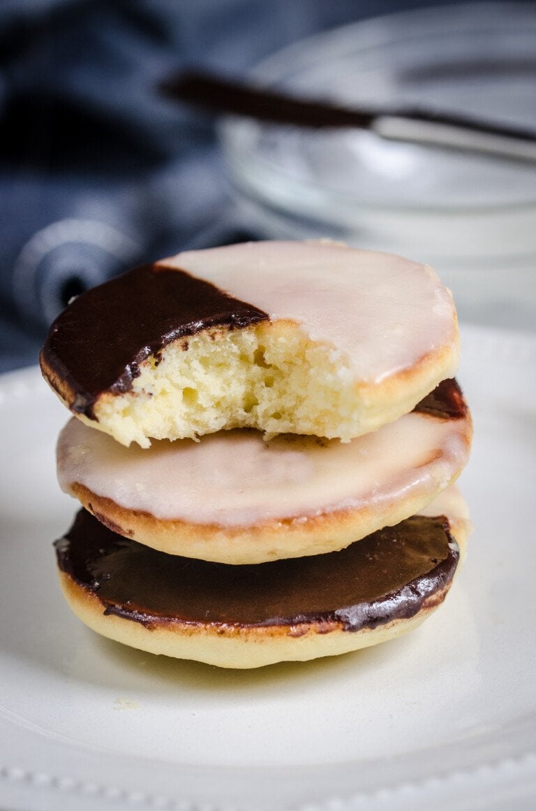 Una pila de galletas blancas y negras, a las que les falta un bocado en la galleta superior.