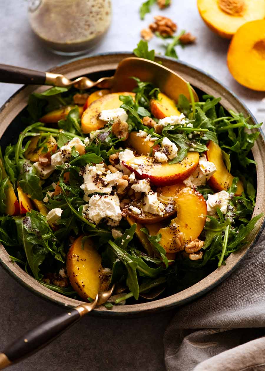Ensalada de durazno con aderezo de semillas de amapola en un bol, lista para servir