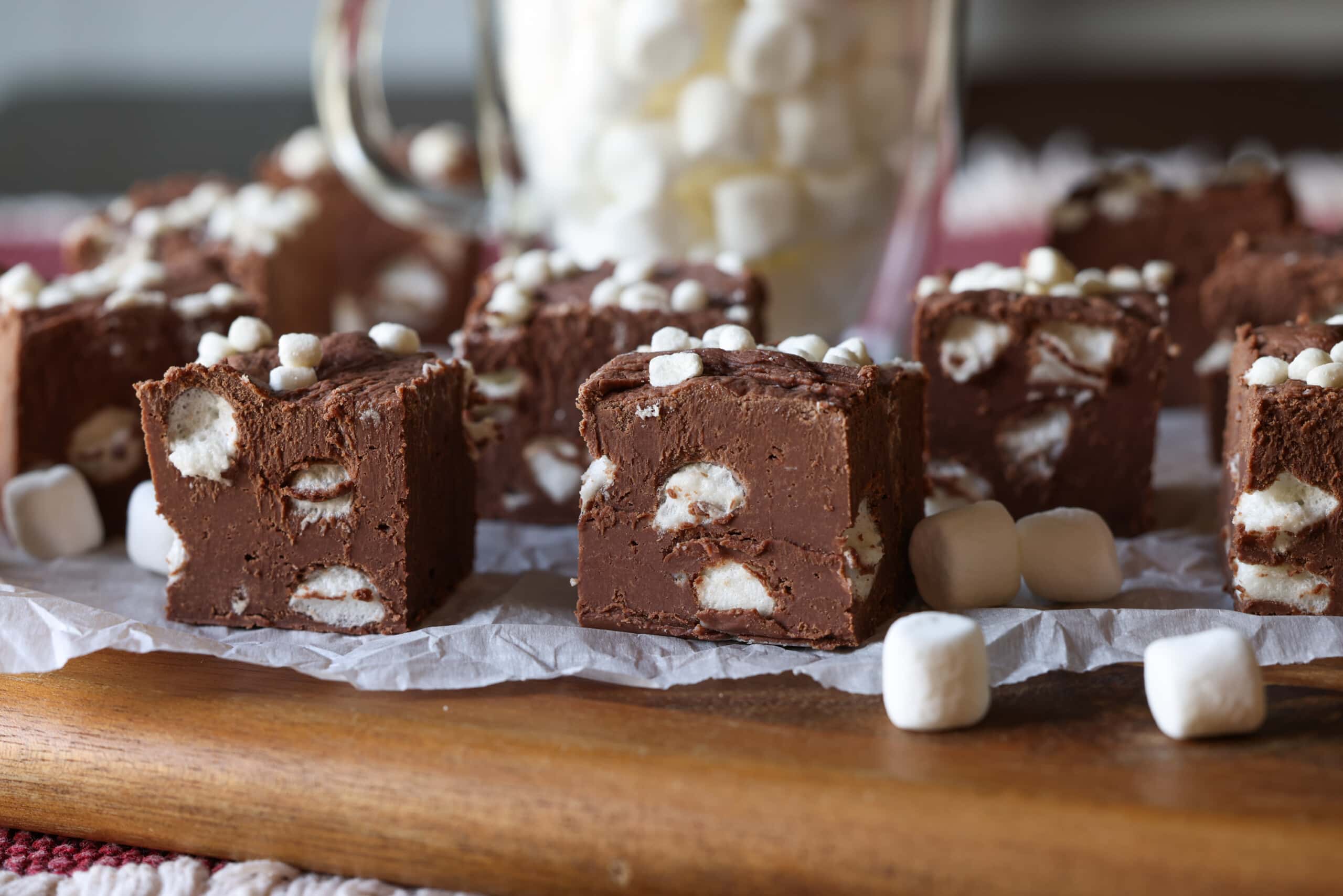 ¡Esta receta fácil de dulce de chocolate caliente combina dos favoritos de invierno en un postre! Fudge cremoso con mini malvaviscos, ¡esta receta es perfecta para regalar en las fiestas! Fudge de chocolate caliente cortado en trozos